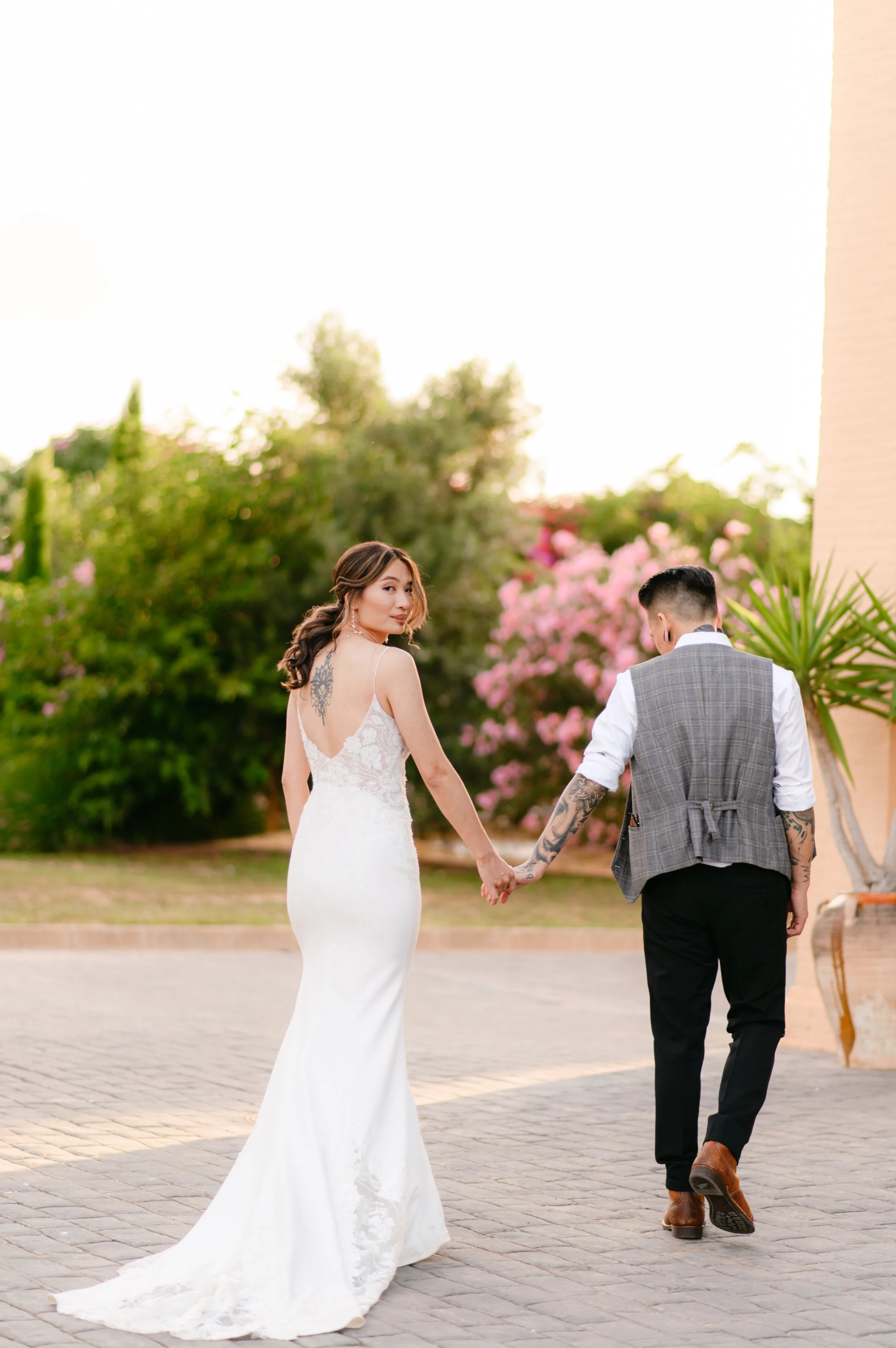 A bride and groom holding hands outdoors during sunset wedding photoshoot in Italy