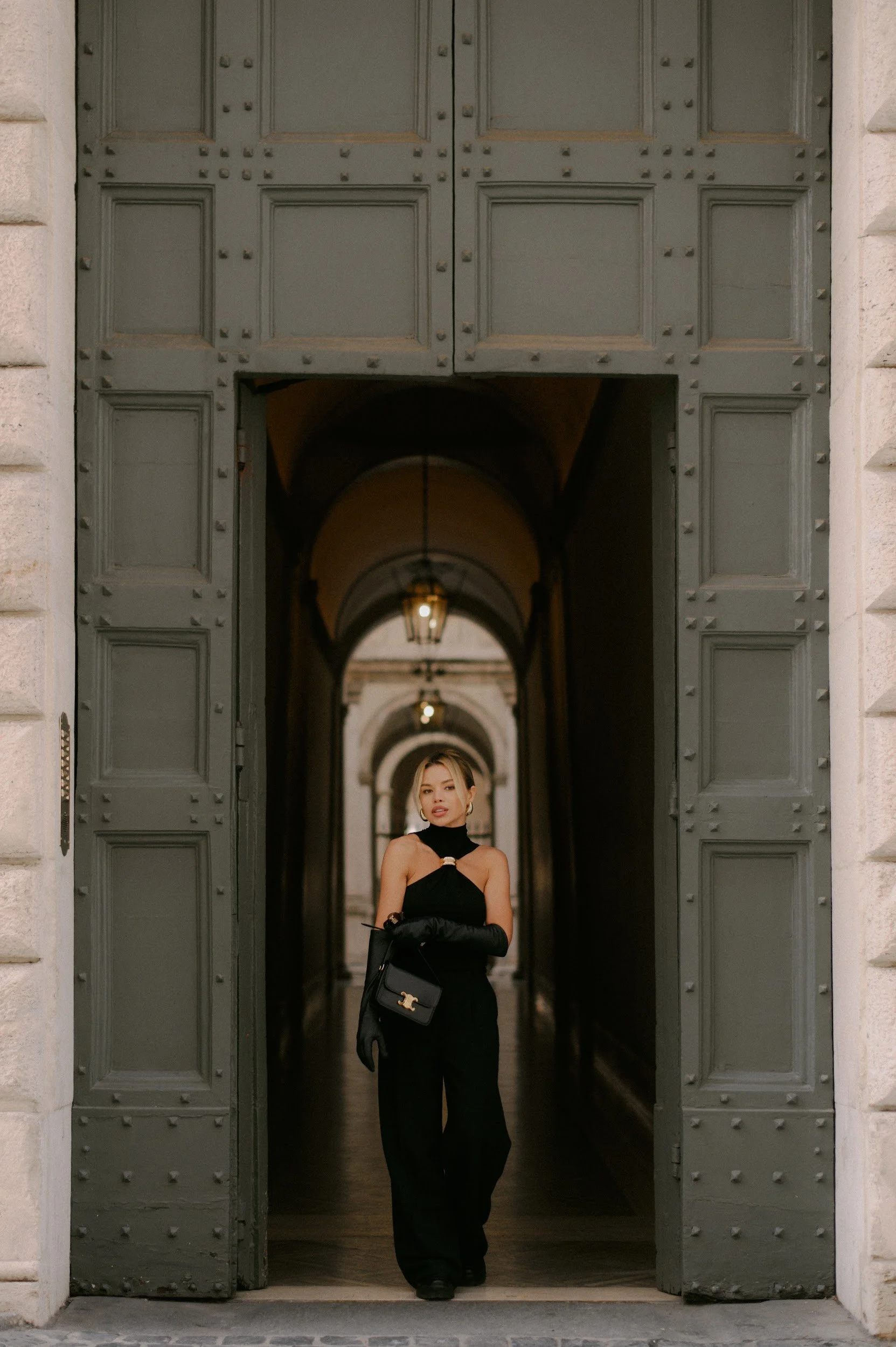 Symmetrical composition in a Roman street with a woman framed by a doorway cinematic aesthetic