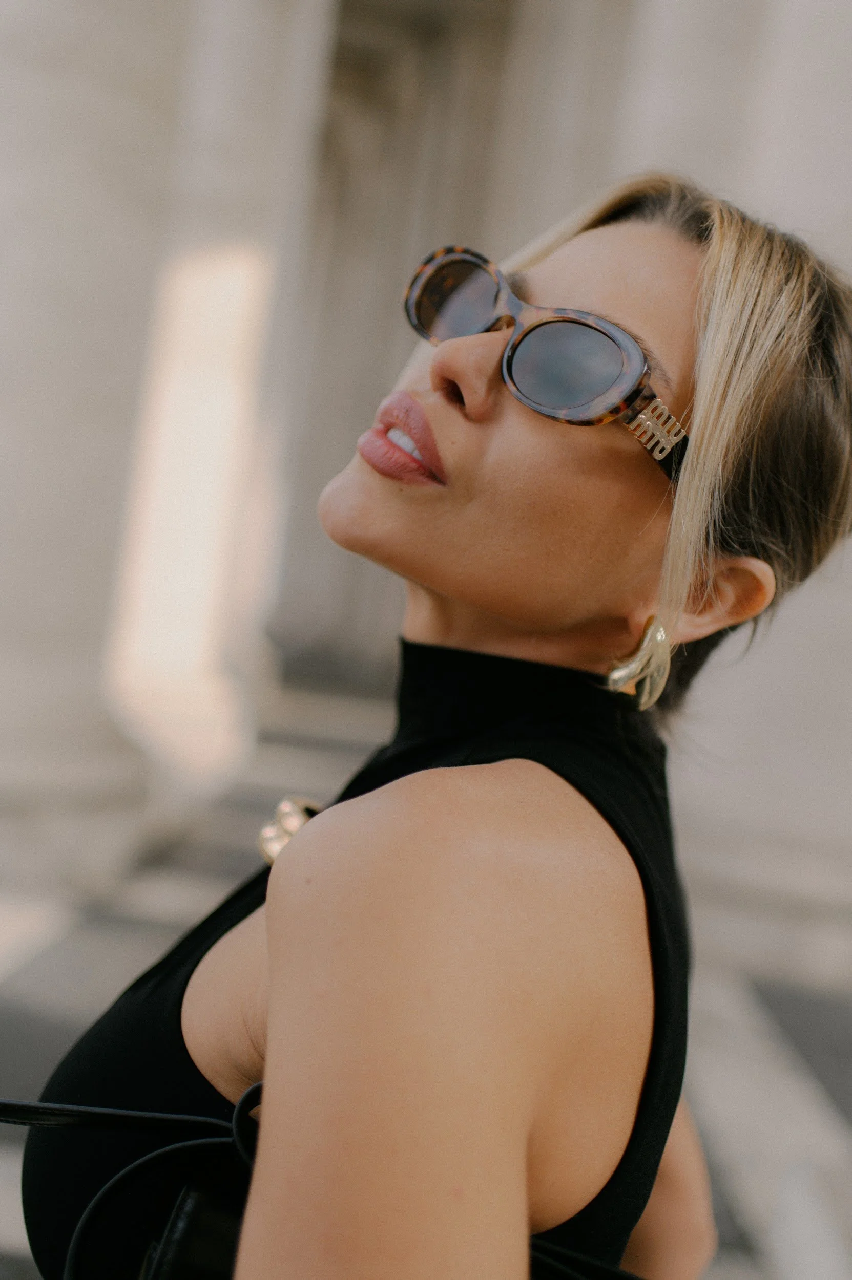 Cinematic fashion portrait in Rome with a woman wearing sunglasses in a bold elegant style