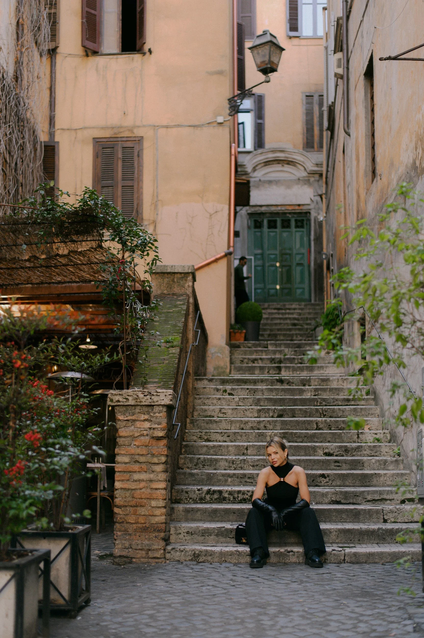 Quiet cinematic moment in Via dei Coronari Rome with a woman in black walking through narrow streets