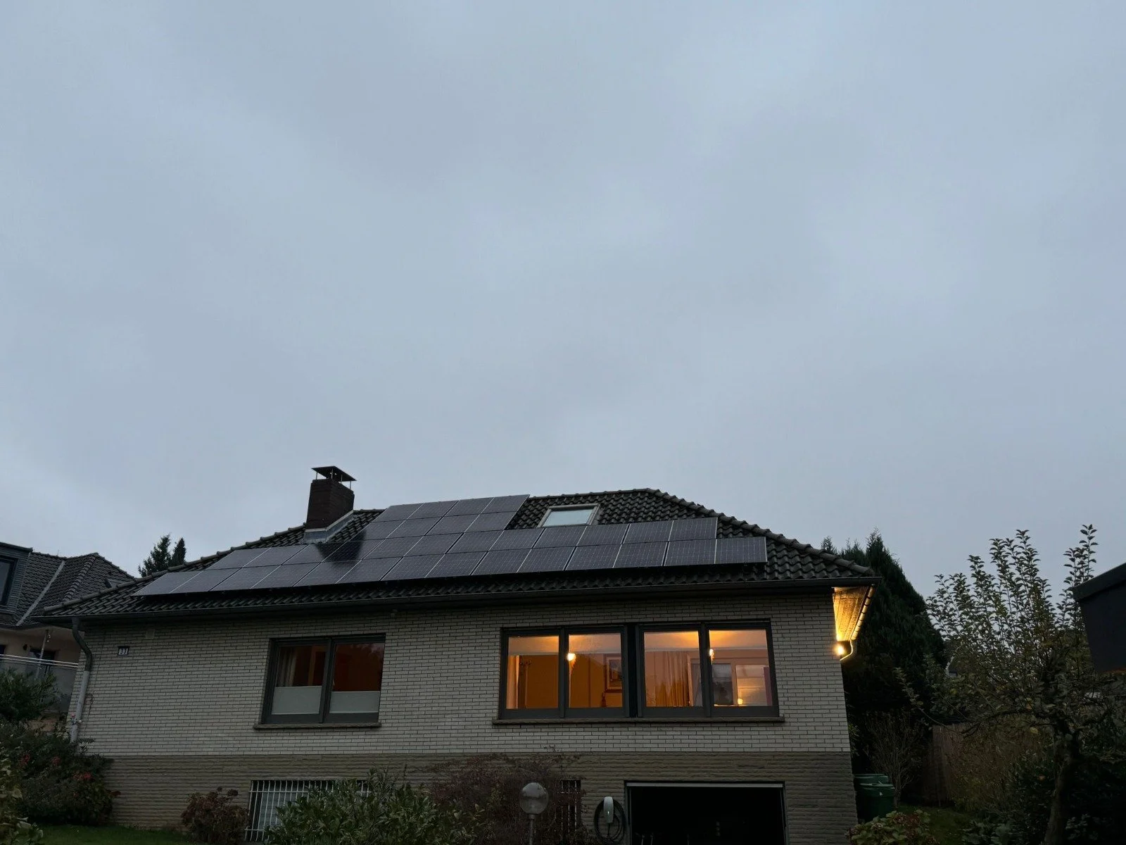 Zufriedene Kunden vor ihrem Haus mit Solaranlage