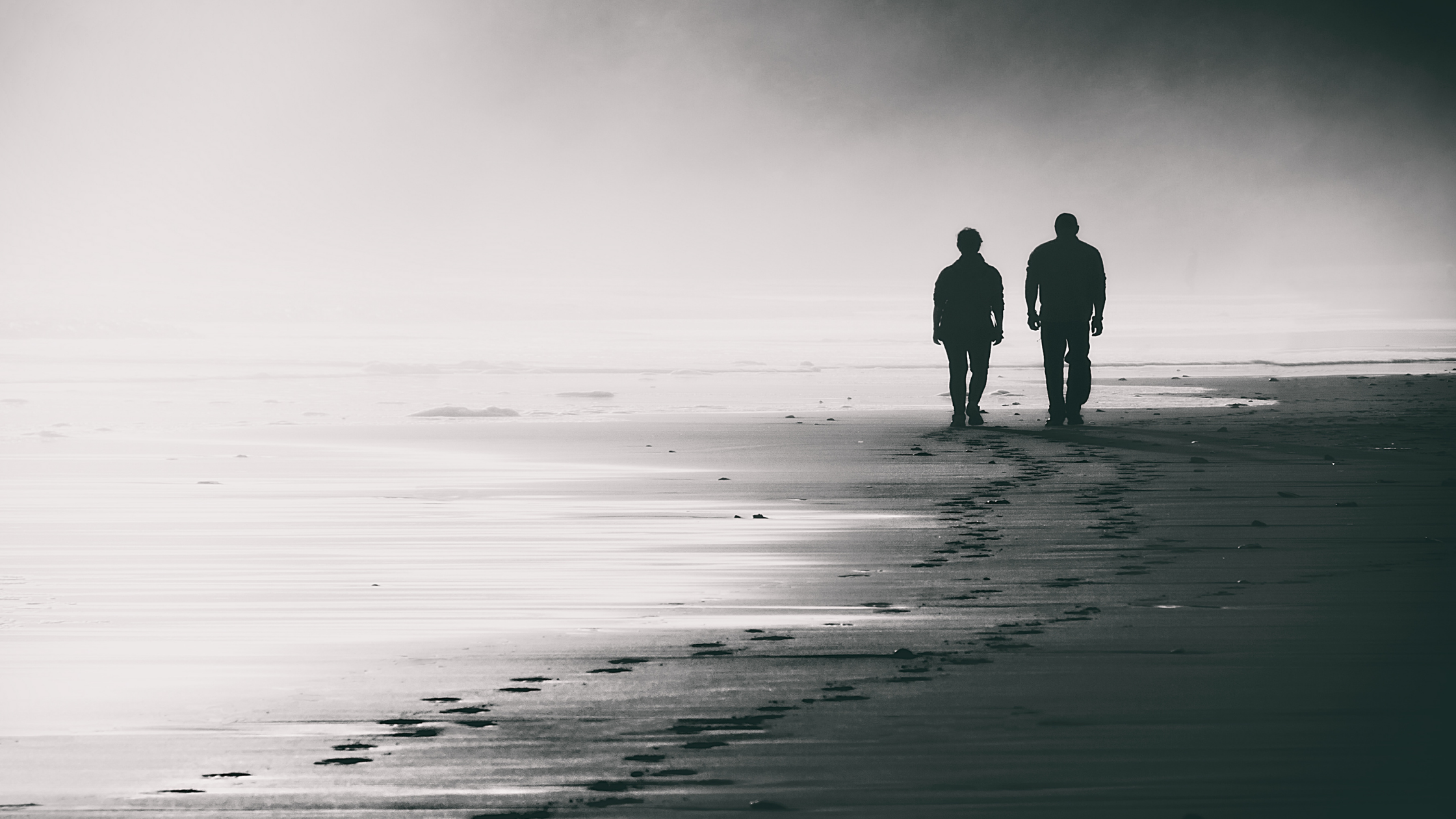 Two people on beach in silhouette