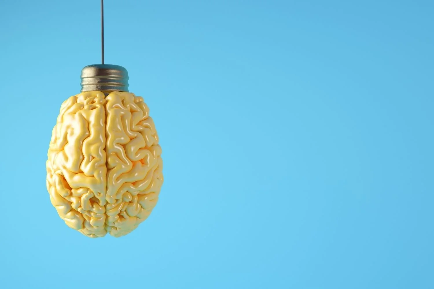 Lámpara en forma de cerebro colgando del techo contra un fondo azul.