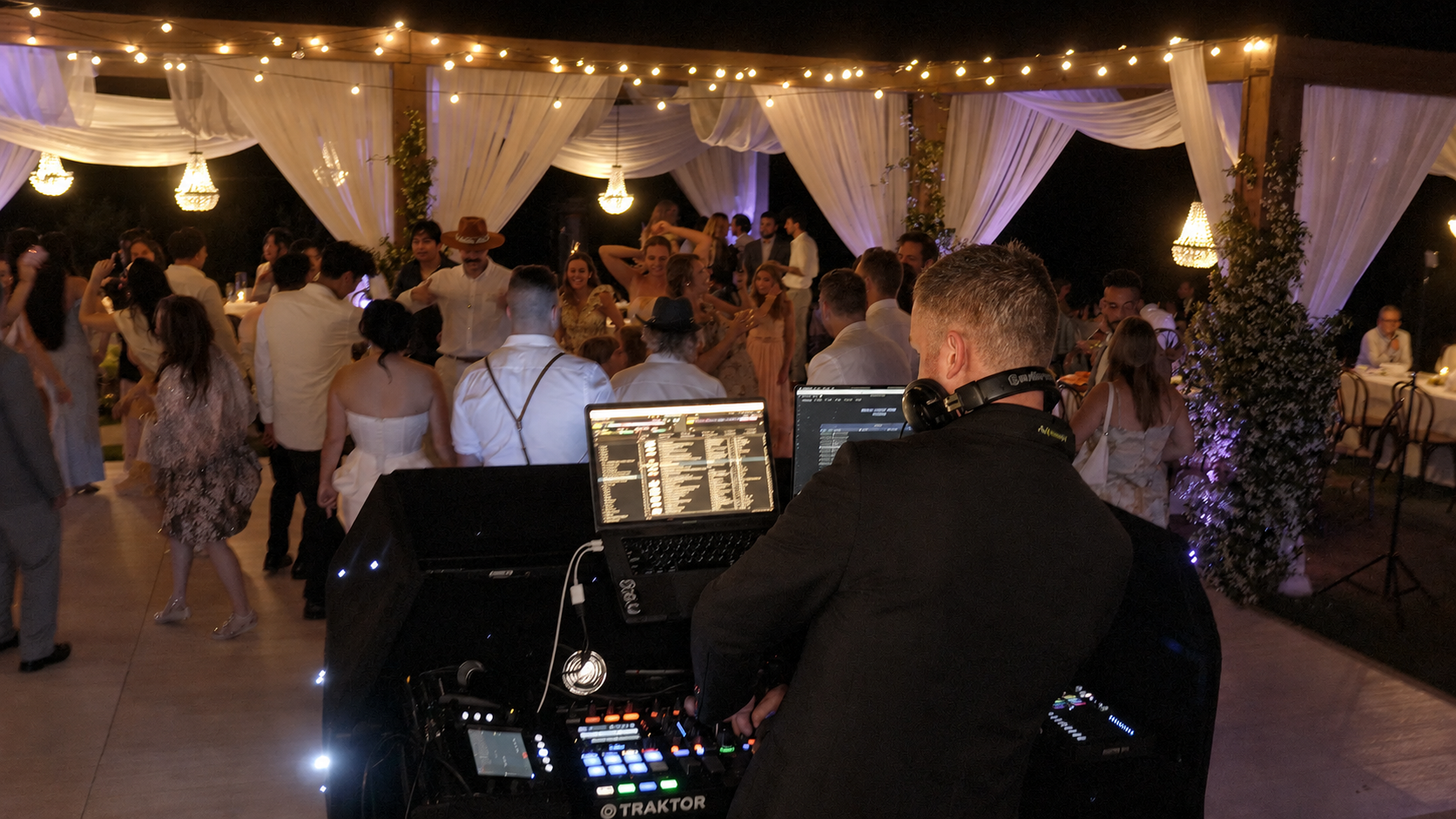 DJ behind a DJ booth at a wedding