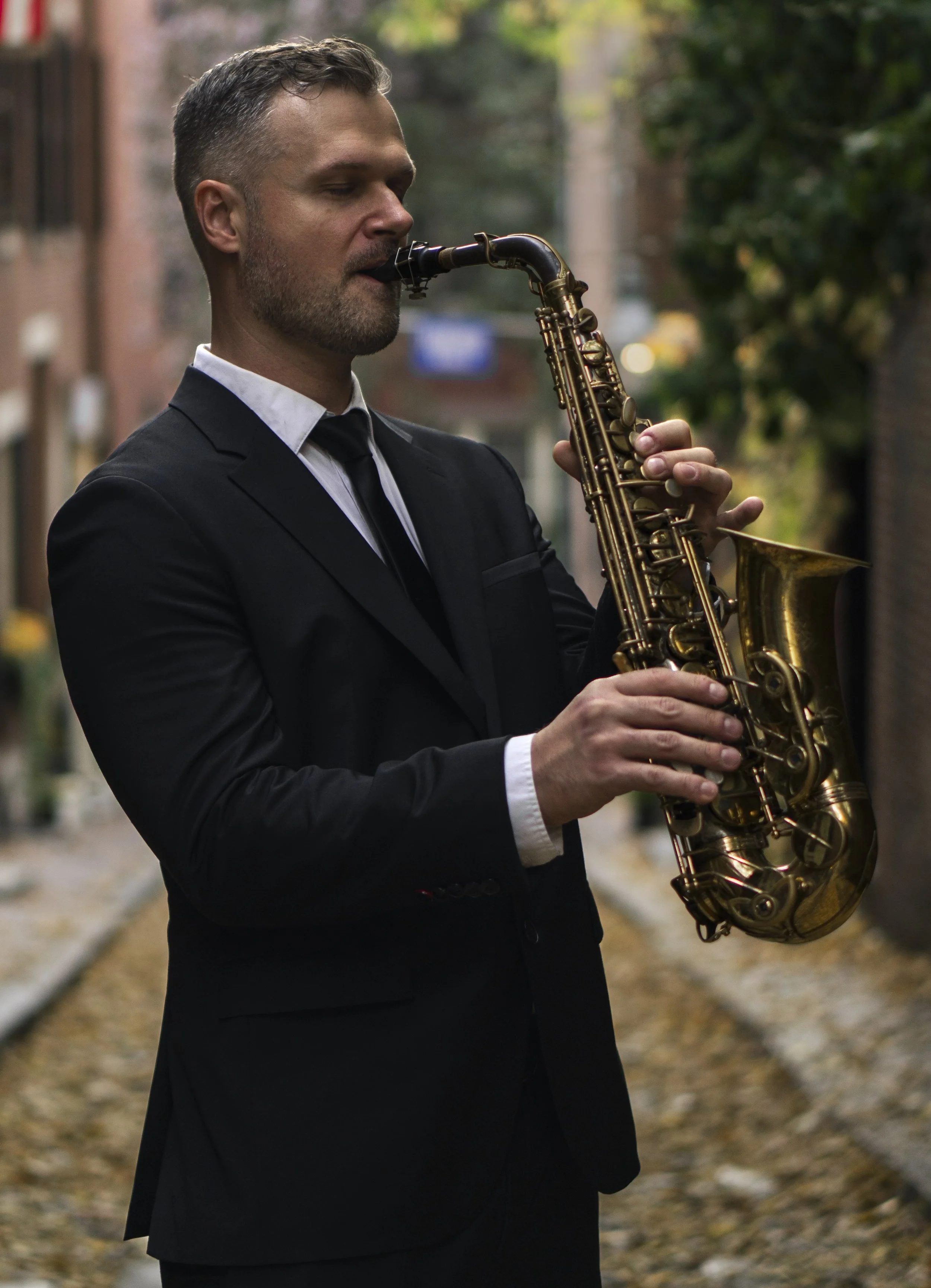 Man holding Saxophone in street