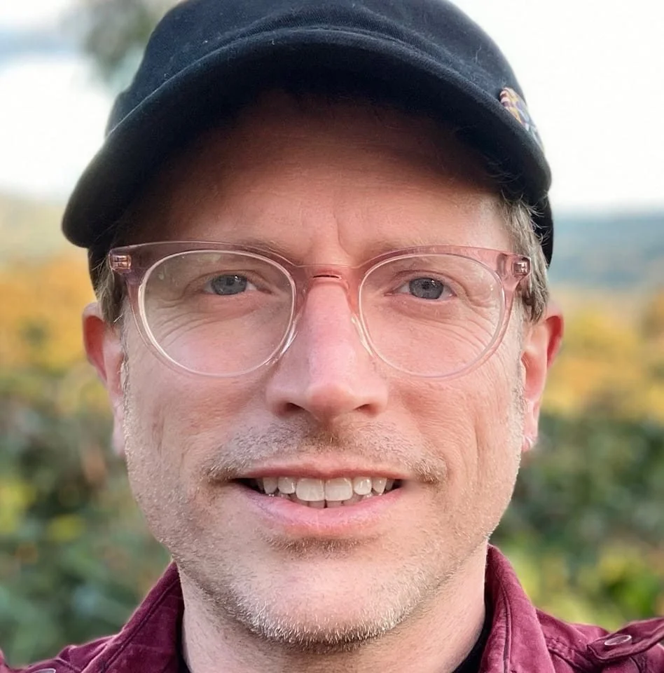 white man in ball cap smiling