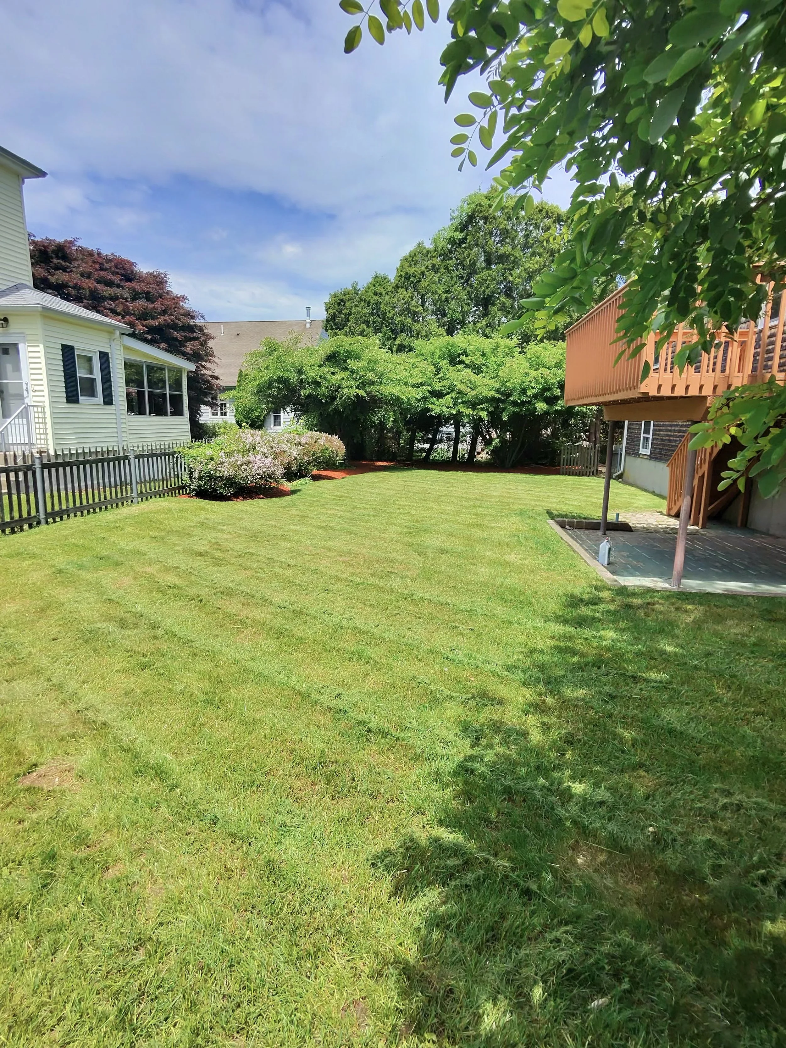 Professional landscaping services including lawn mowing, mulch installation, and edging by C&E Services in Rhode Island & Massachusetts