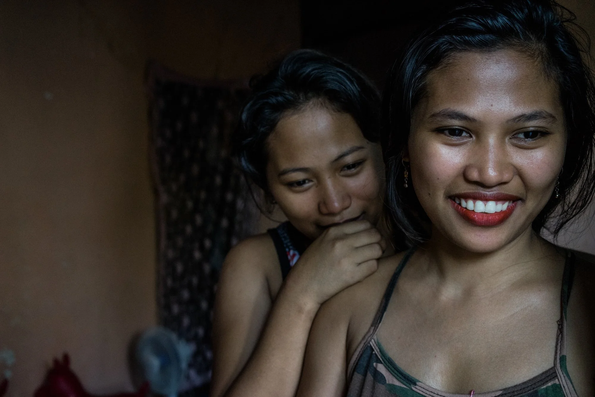  Sisters Gemma (right) and Joanne in their home in Angeles City, which is notorious for its sex industry and its red light district. Shortly after being displaced from Typhoon Ruby, Gemma followed her sister to Angeles to work as a prostitute. (Photo