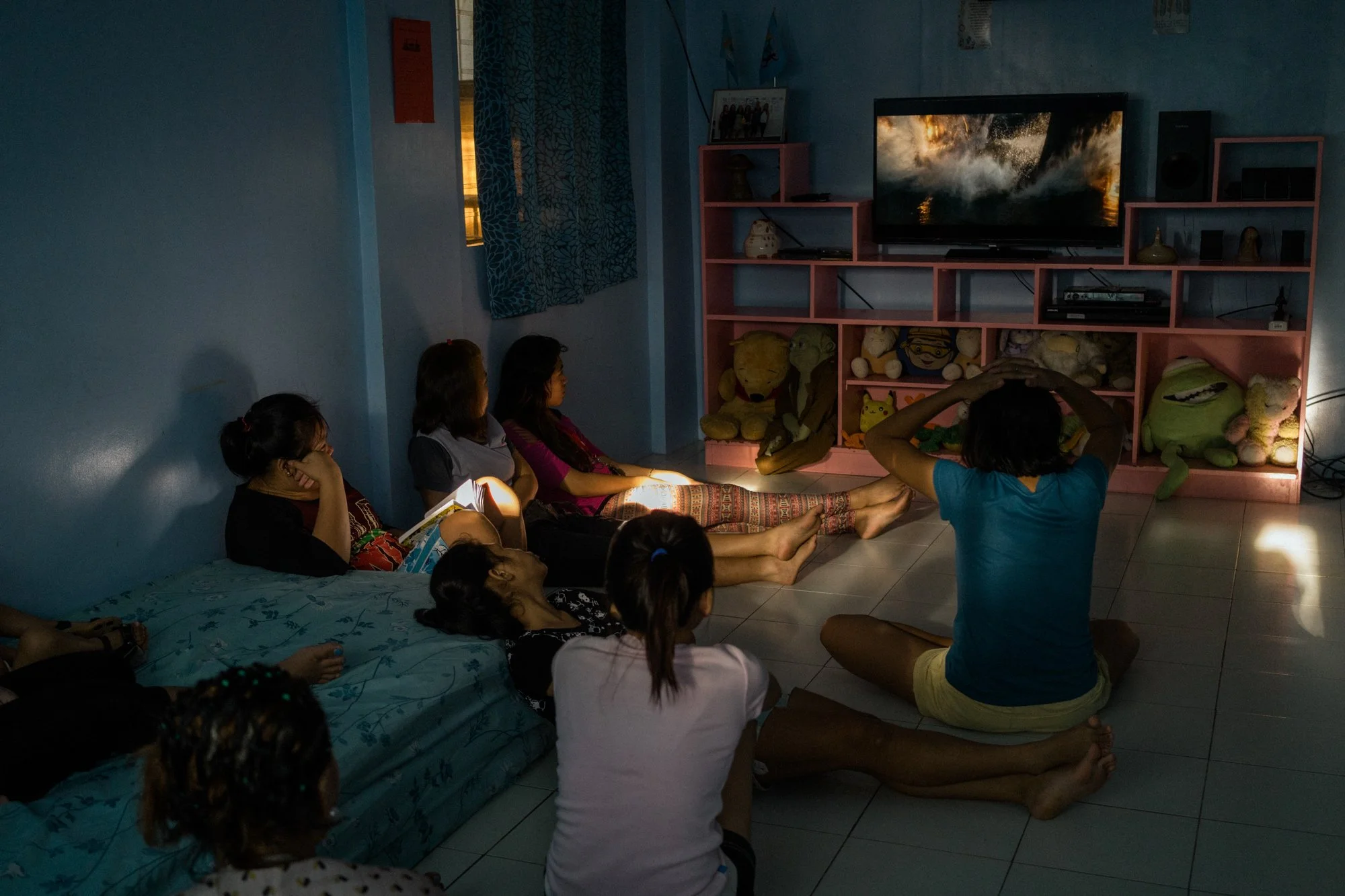 Girls watch television at a halfway house for victims of sex trafficking. Here, girls who are rescued get counseling, shelter, legal assistance, and, for some, education. 