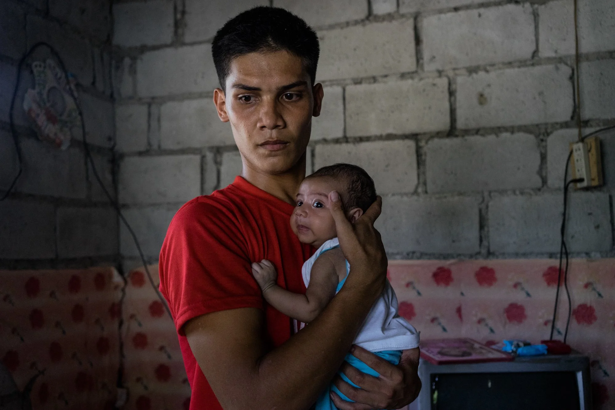 Tisoy, Jojo’s husband, plays with their son in their home. Because of Jojo’s work, Tisoy has has to be a stay-at-home father to their children. 