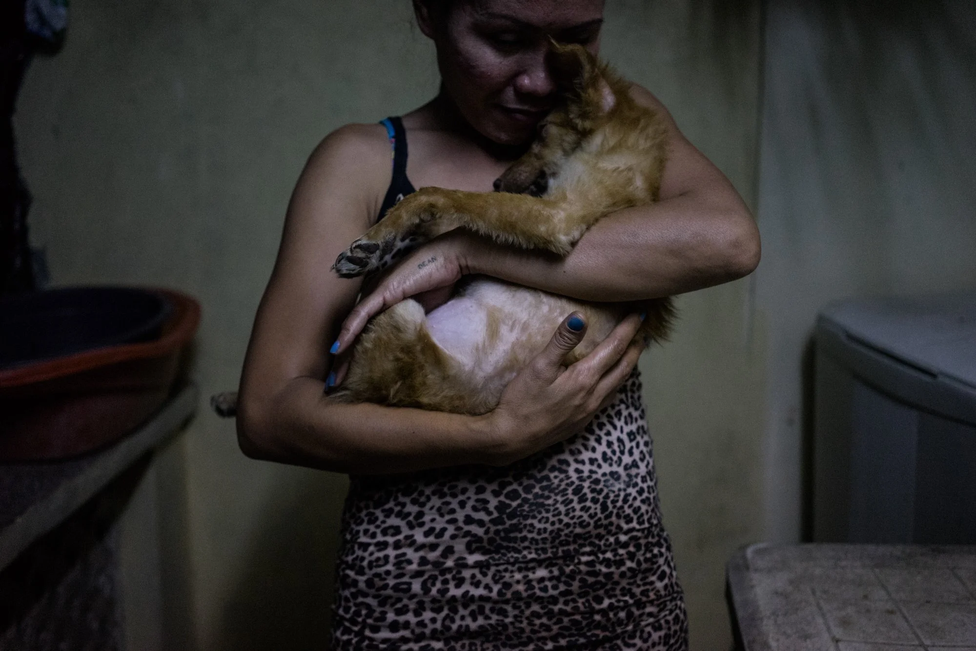 Rose, a sex worker in Angeles city, hugs her dog. 