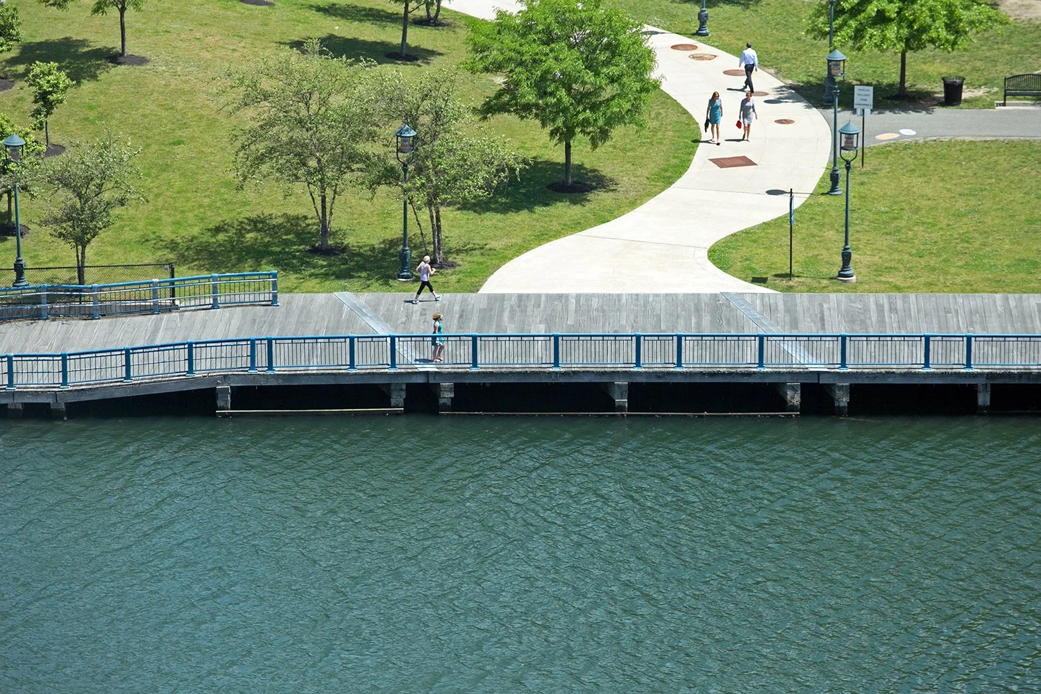 People walk and jog on the Harborwalk in Boston. 