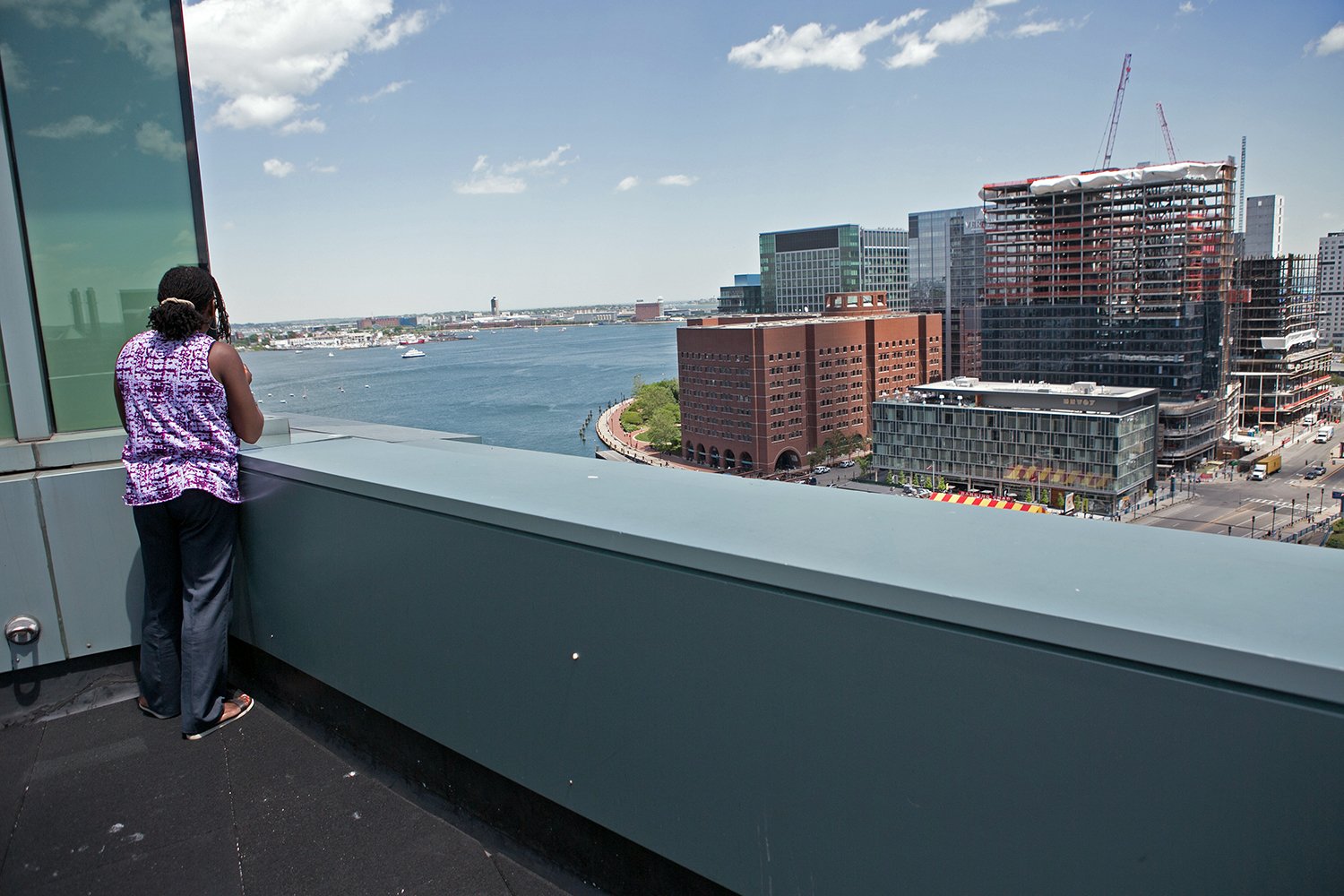 Movita Harrigan looks out on a new development in South Boston, June 6, 2016. 