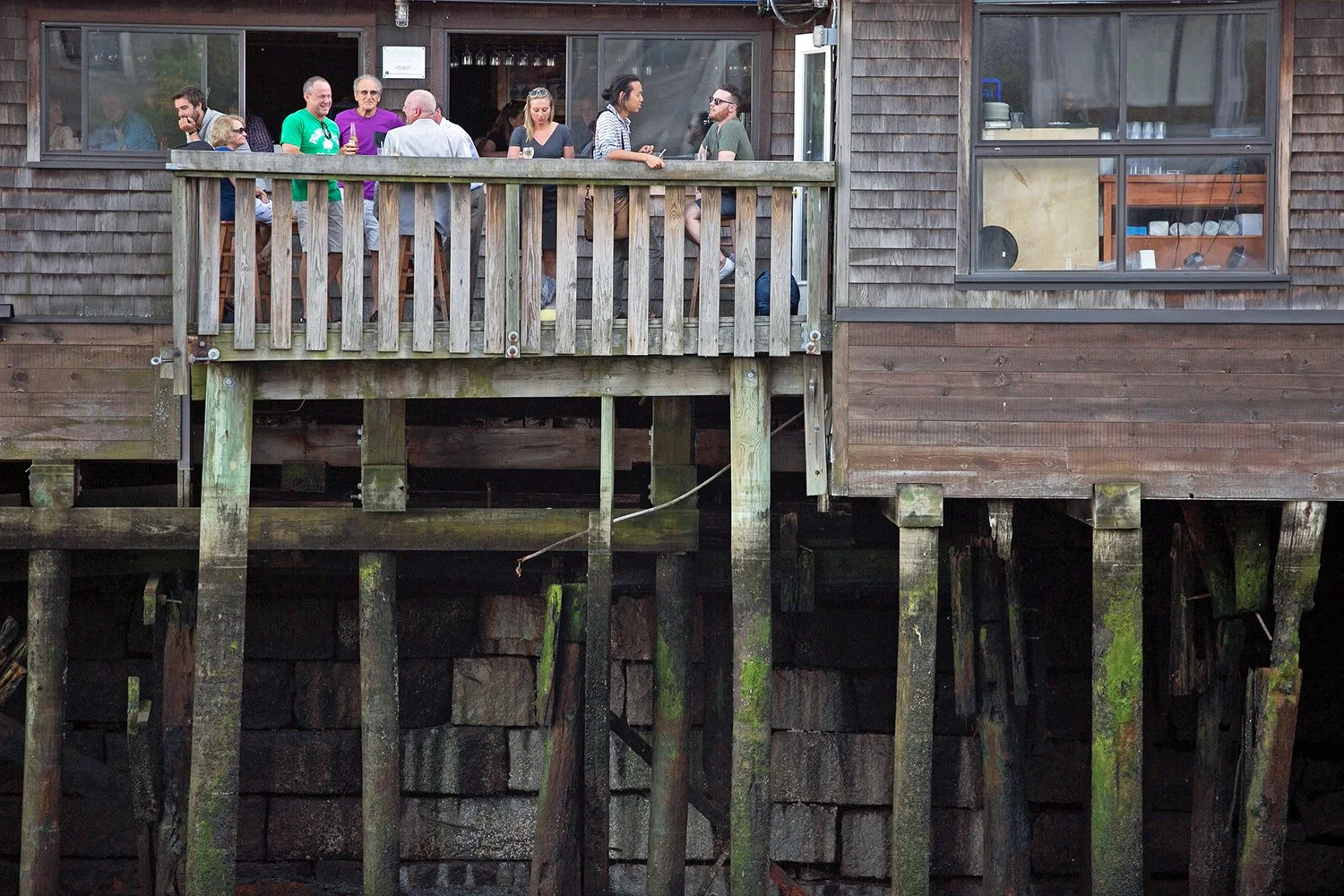 People eat and drink on top of old pilings at Boston Sail Loft restaurant in the North End on June 6, 2016. 
