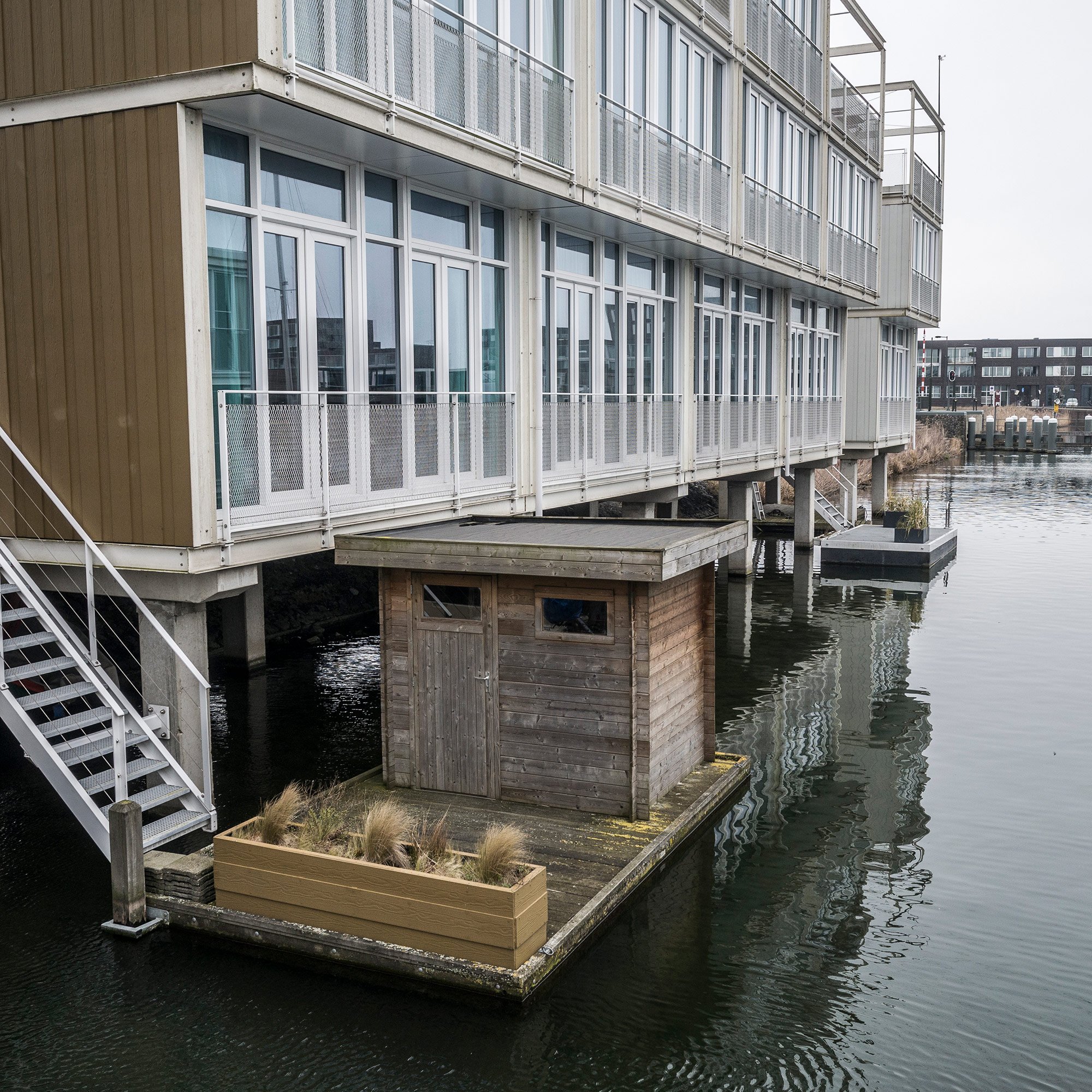 IJburg is a neighborhood of floating houses on the eastern edge of Amsterdam. A garden shed and plants are pictured. 