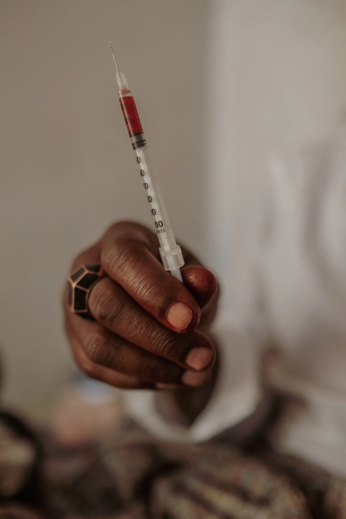  Locals use a concoction of heroin and Kool-Aid to fill needle syringes for drug use. (Photo by Asha Stuart/GroundTruth) 