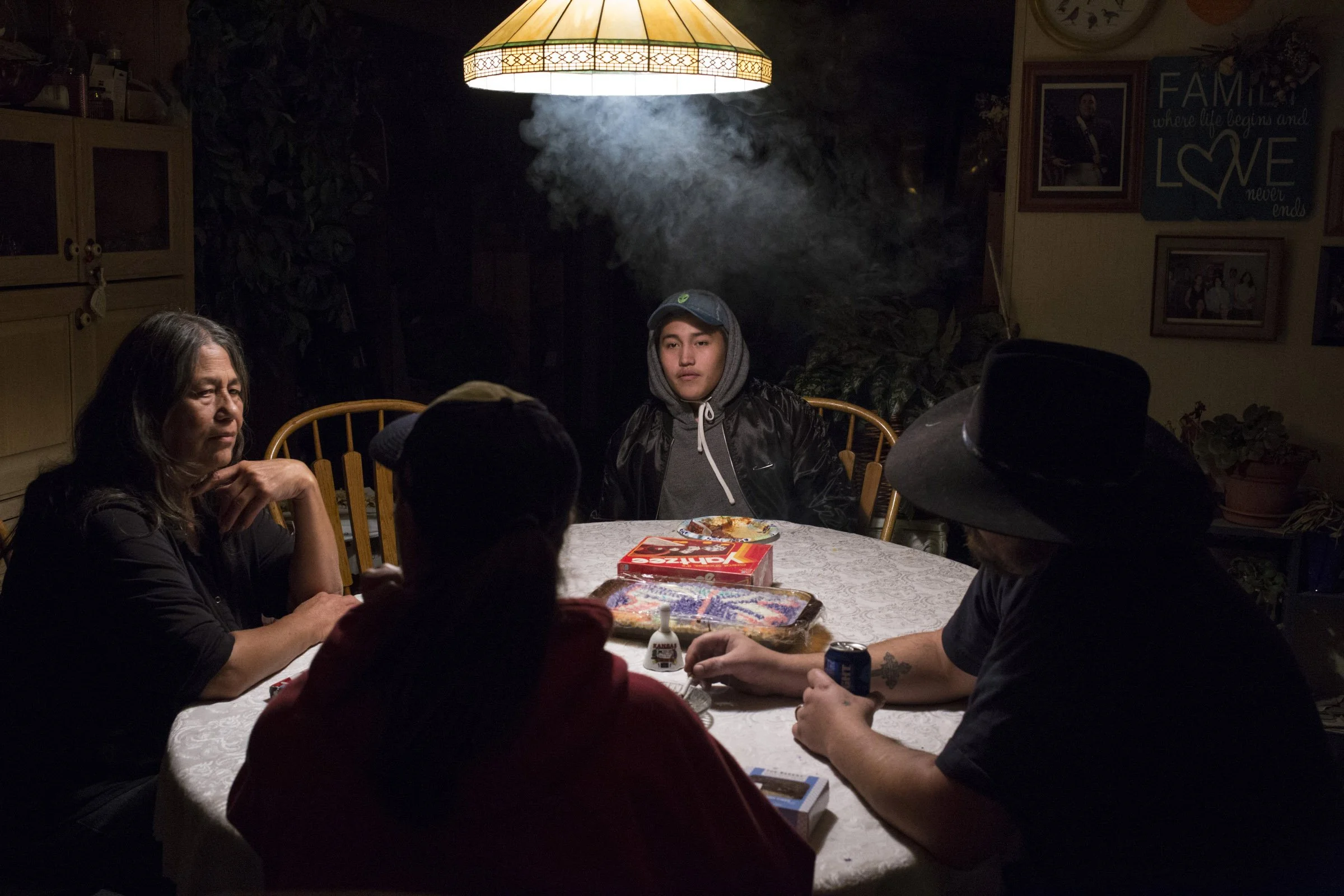  Xavier Smith, 17, sits at the kitchen table with his grandmother (left), mother (center), and his mother’s boyfriend (right) at his grandmother’s home in Pablo, Montana, on Saturday, October 21, 2017. (Photo by Brittany Greeson) 
