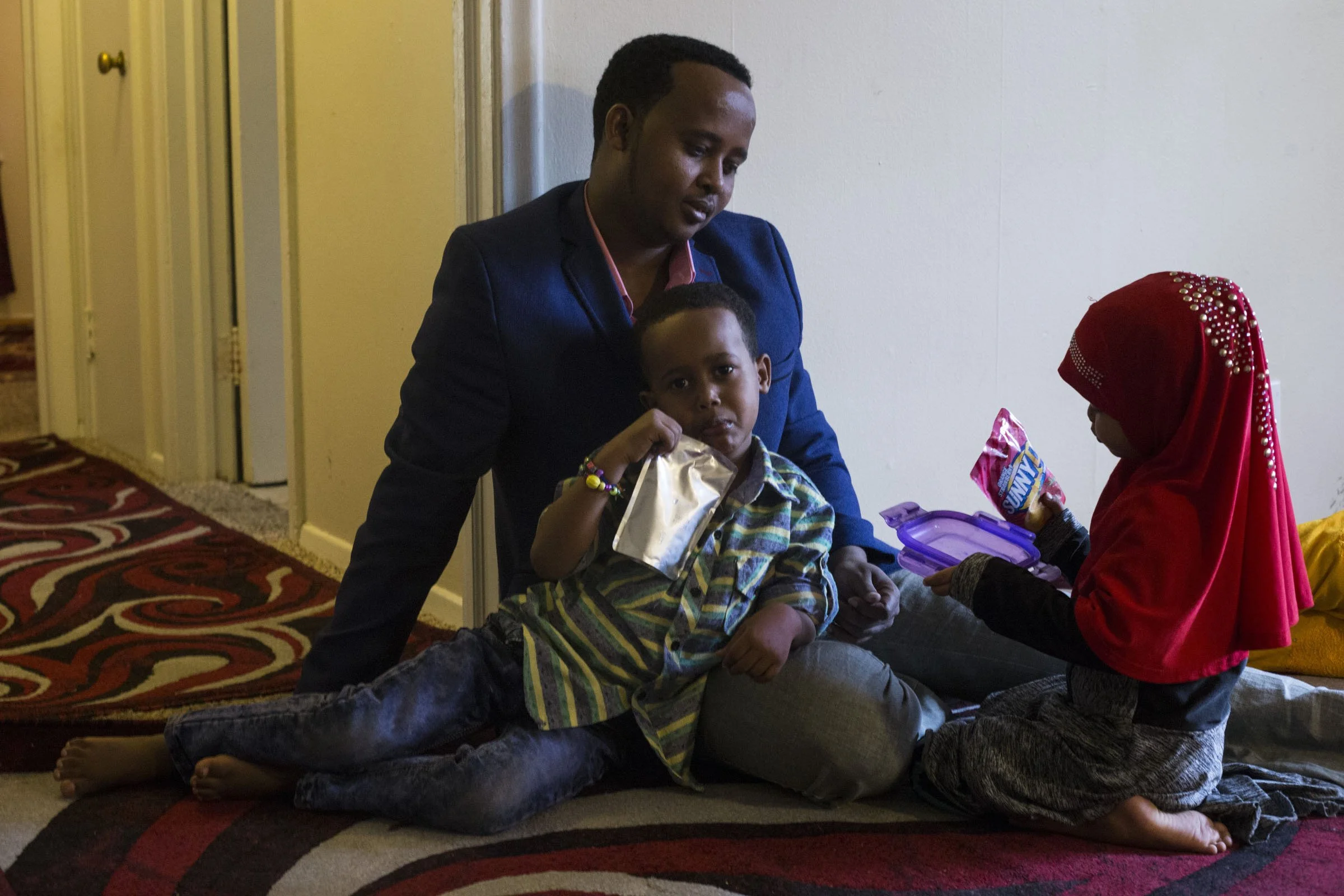  Mustafa Noor, 4, drinks a Sunny D while laying on his father’s lap, Kassim Noor, 30, alongside his sister Asmi Noor, 3, at their home in Faribualt, Minn., on Friday, October 13, 2017. In early February, Kassim’s family was held back from immigrating