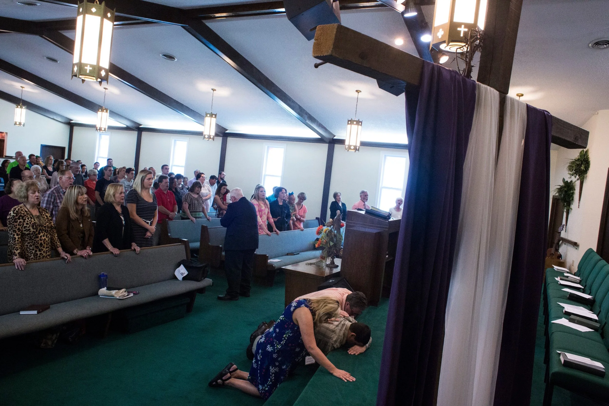  Mary Sloane, an English teacher at Floyd Central High School, prays for a member of her congregation at First Baptist Church in McDowell, Kentucky, on Sunday, September 24, 2017. (Photo by Brittany Greeson) 