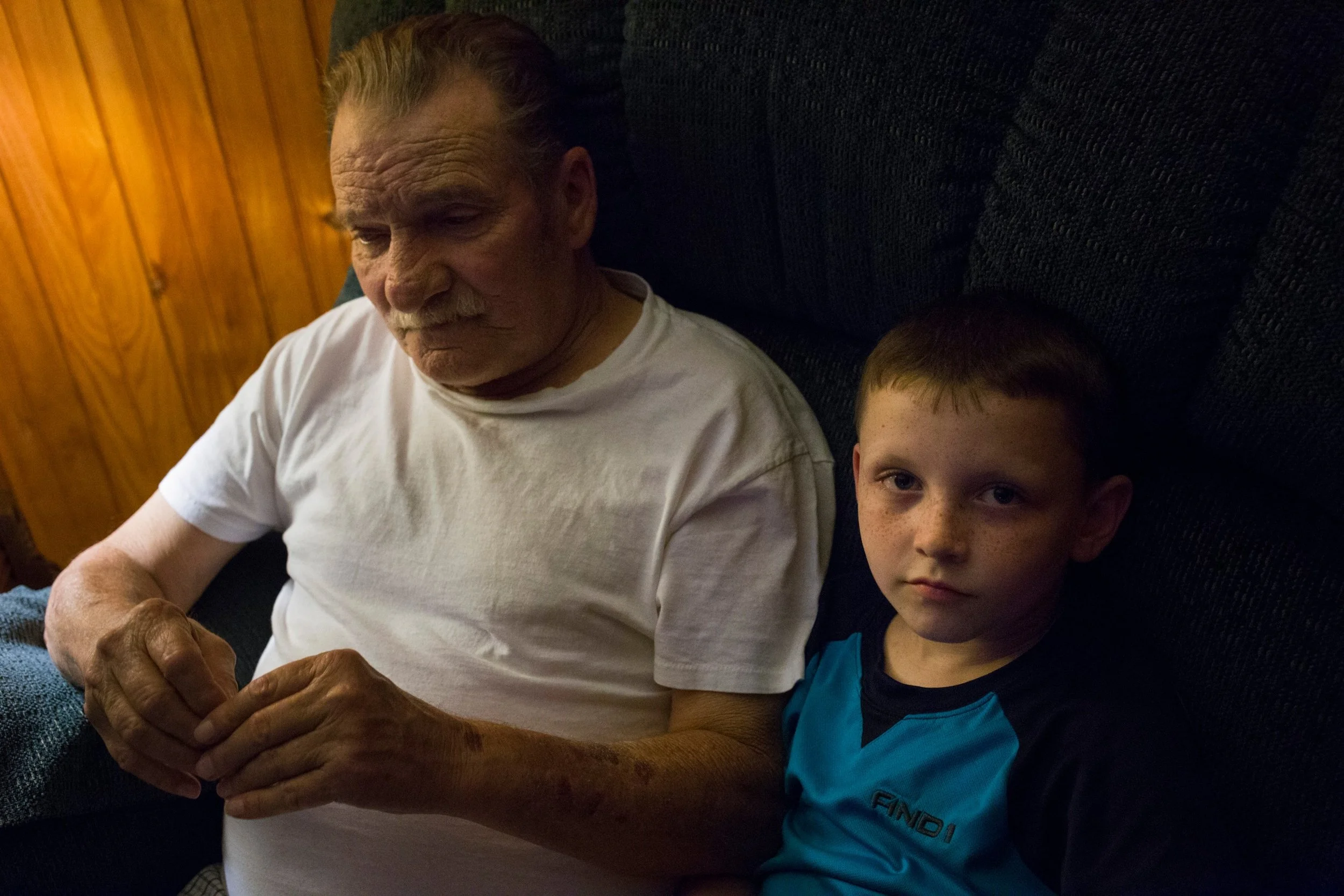  Chase Newman, 8, sits in a reclining chair with his grandfather Doff Justice as he watches TV at their home in Grethel, Kentucky, on Thursday, September 28, 2017. (Photo by Brittany Greeson) 