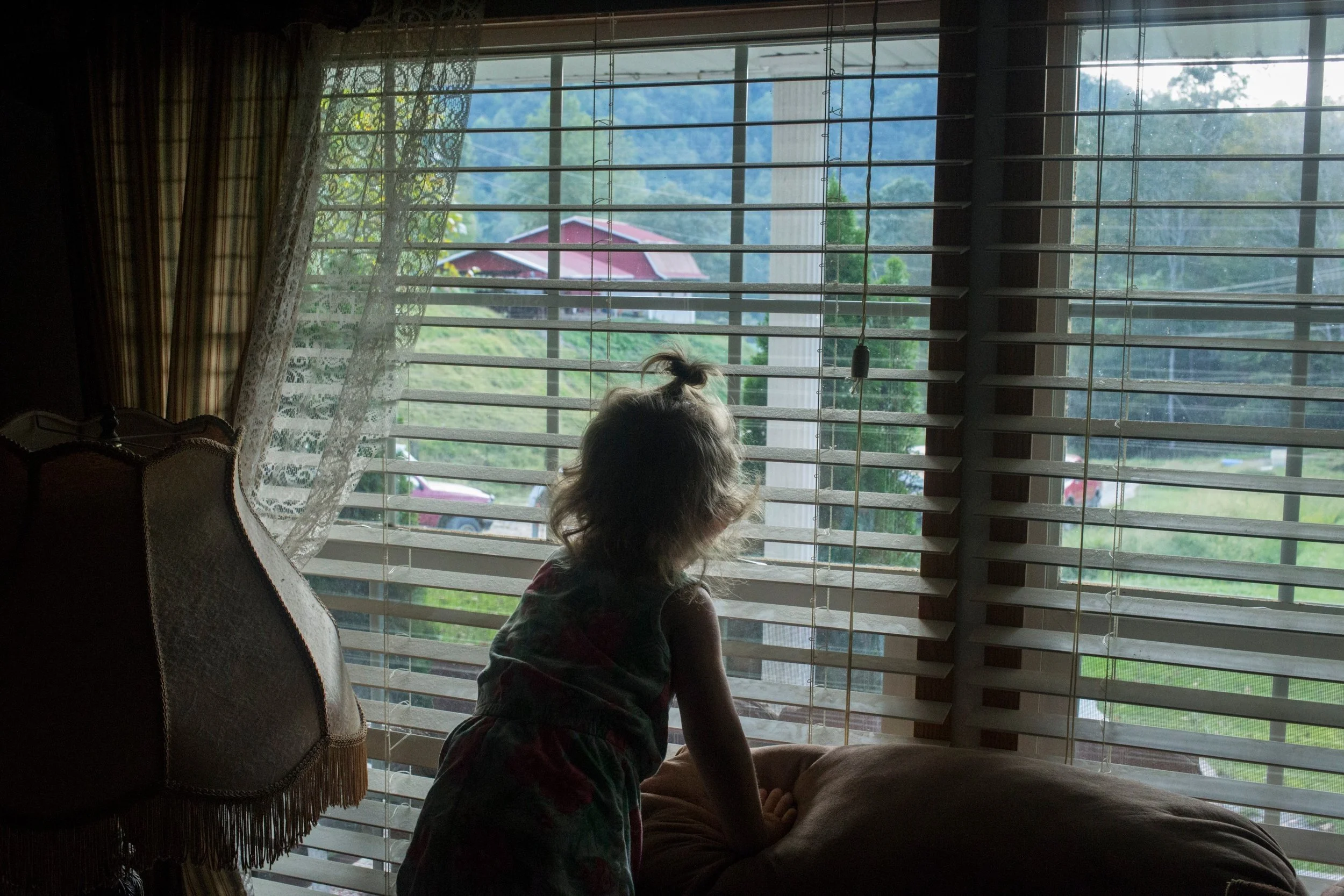  Paisley Jarvis, 2, peeks out the window of her father’s living room in Langley, Kentucky, on Tuesday, September 26, 2017. (Photo by Brittany Greeson) 