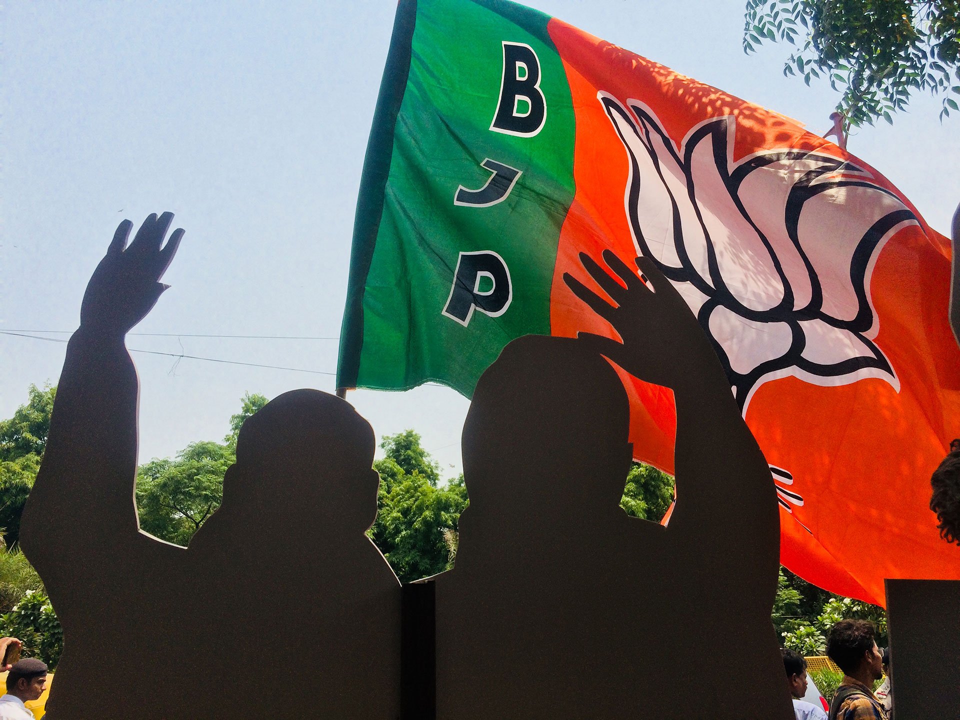   BJP supporters prop up Modi and Shah placards as they celebrate with firecrackers and music. — (Photo by Mohit Marwah/GroundTruth)  