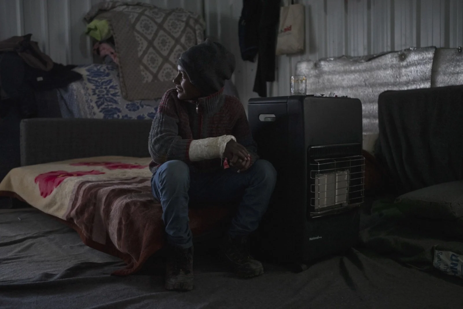  Ahamd Caher, 15, a Syrian refugee from Golan Heights, sits on a bed in his family’s caravan in Azraq refugee camp, January 19, 2016. (Christopher Lee/GroundTruth) 