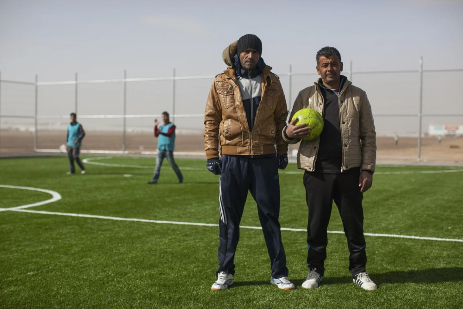  Mousa Hassan (left), 35, and Mamon Gabao (right), 37, both Syrian refugees from Daraa and coaches trained by the Premier League for the soccer program, pose for a portrait during a soccer match on one of the pitches provided by World Vision at Azraq