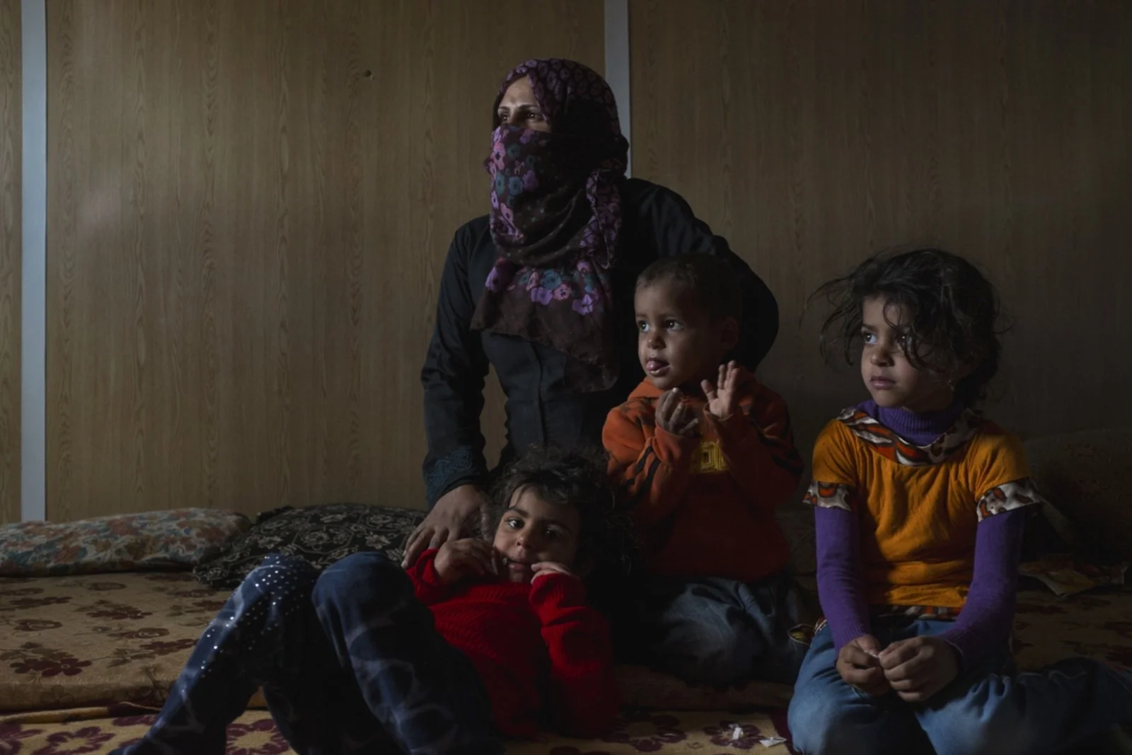  Ammeh Salah (center left), 29, from Damascus, sits with her children Jhazel (right), 6, Mohamed (center right), 3, and Arreeg (left), 5, in their caravan in the Zaatari refugee camp. Ammeh, a single mother, whose husband disappeared in Syria, suppor