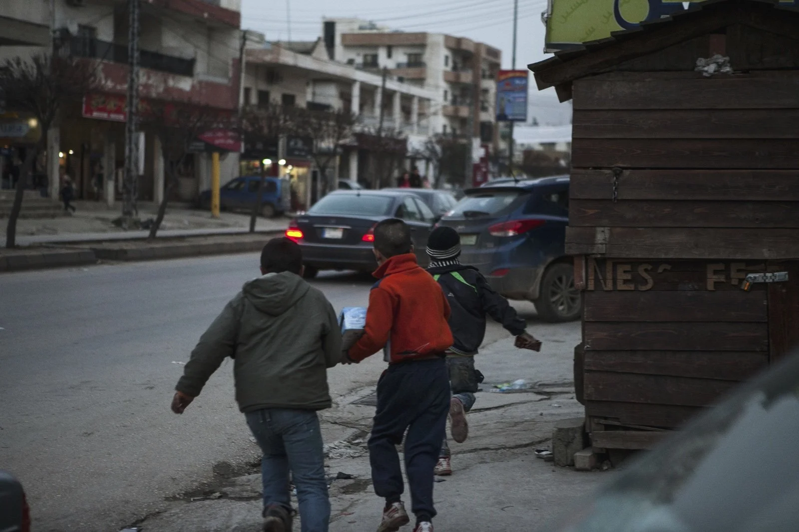  Syrian refugee children run away from a Lebanese store owner who chased them from his property in the Bekaa Valley. (Christopher Lee/GroundTruth) 