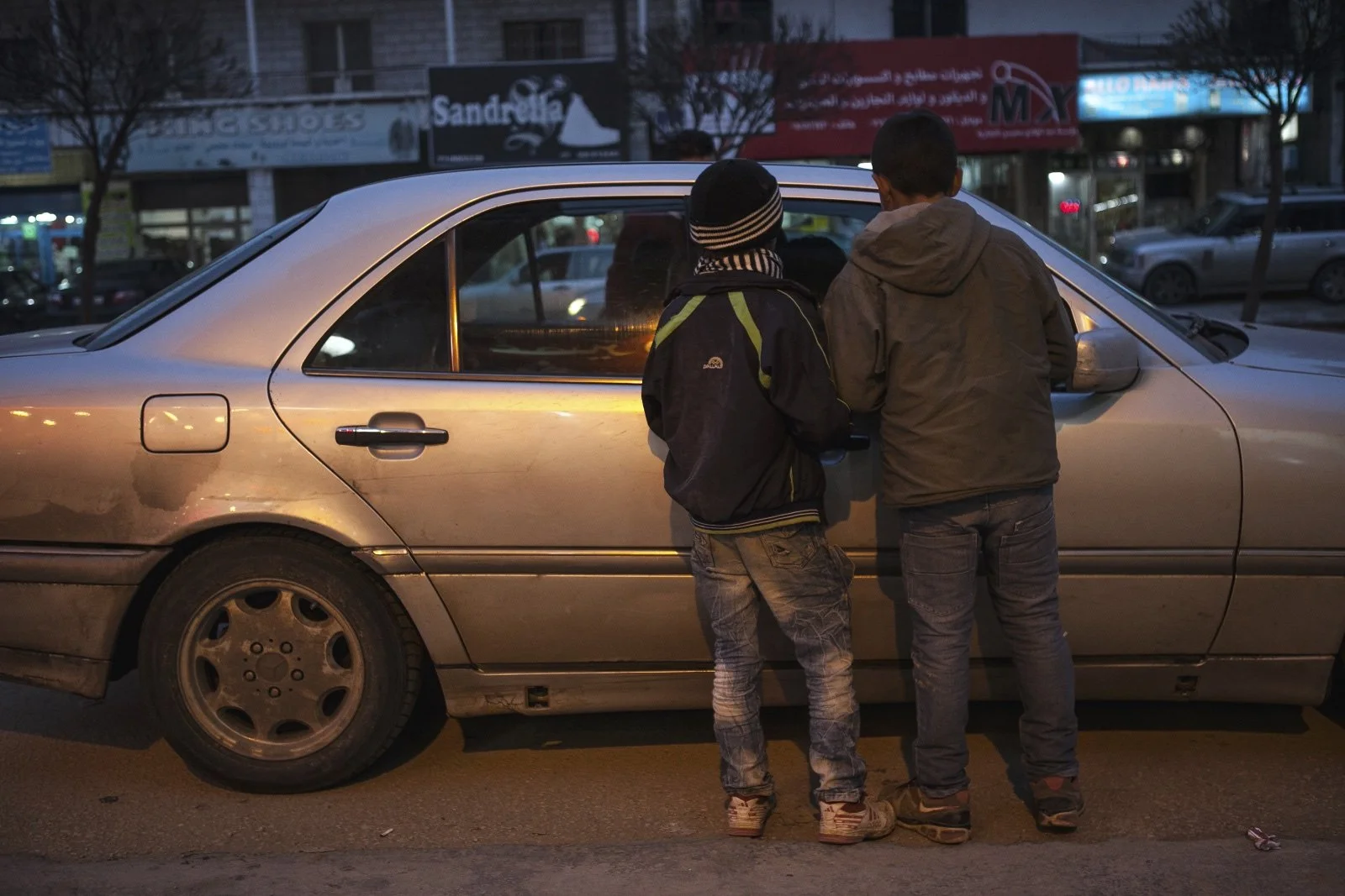  Mahmut, 8, a Syrian refugee from Homs, approaches a car in the Bekaa Valley, attempting to sell biscuits. Because of limited opportunities for Syrian refugees to work in Lebanon, women and children are forced into a world of exploitation and abuse w