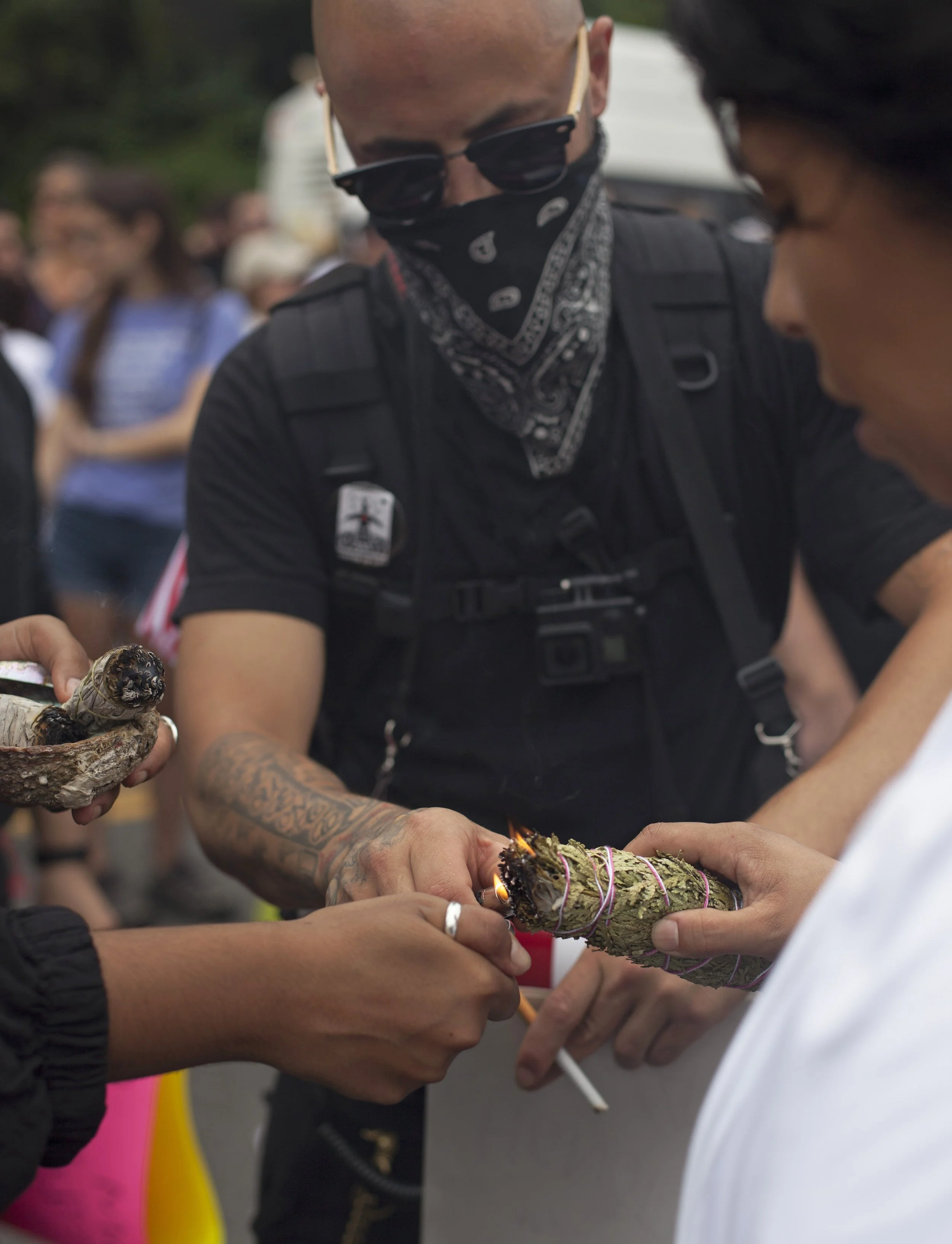  Counter protesters burn sage while amassing at the Reggie Lewis Track &amp; Field Center in Roxbury. The counter demonstration was against the Free Speech rally at the Boston Common. (Shay Horse/GroundTruth) 