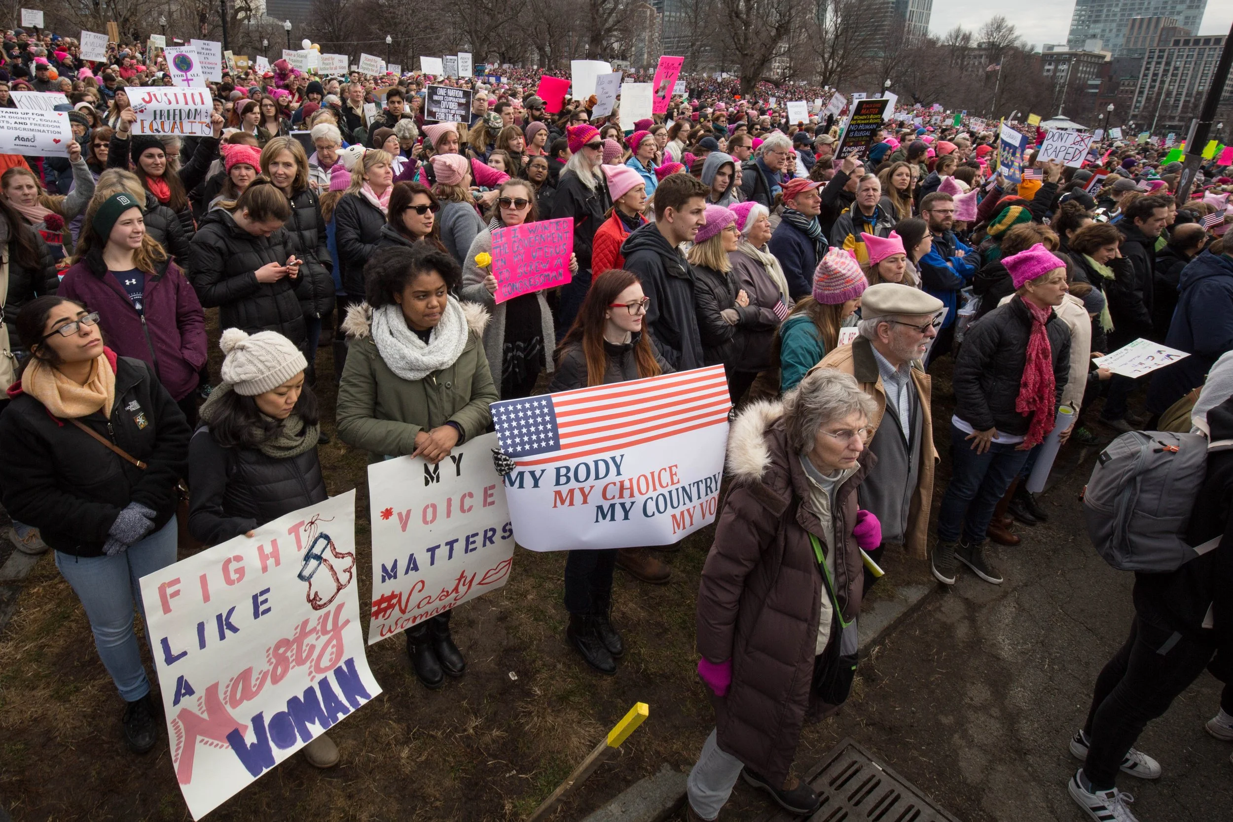  Kristen Coogan, 24, of Marlboro, Mass. (right), and Jessica Pierre, 24, of Somerville, Mass. (center), look on during the Boston Women’s March on Jan. 21, 2017. (Photo by Alastair Pike) 