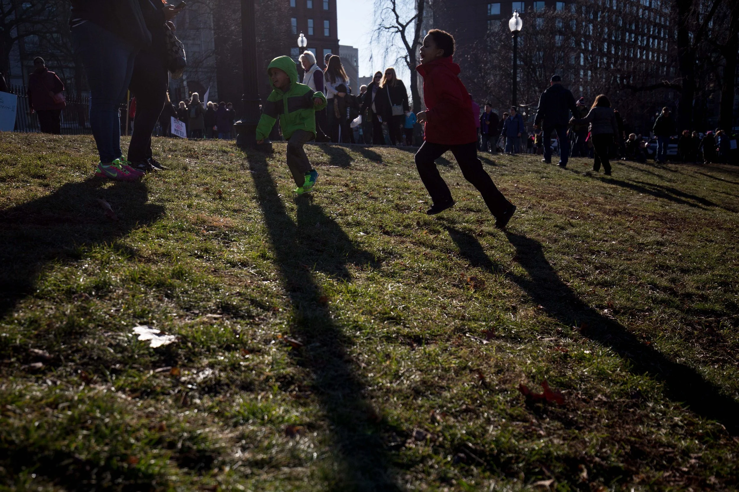  “I feel good … I’m marching for women’s rights,” says 8-year-old Taharka Parry, right, as he plays with his 3-year-old brother while his mother, left, looks on. (Photo by Alastair Pike) 