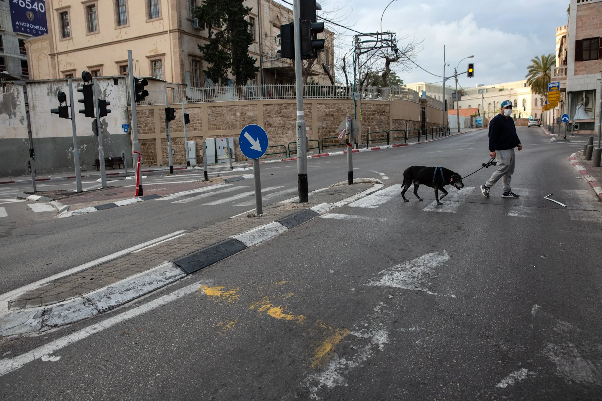  Eldad Cohen, 46, is seen wearing a protective mask as he walks his dog Boogie along a deserted main road in Jaffa. Israelis across the country were in lockdown on the Passover Eve, April 8, 2020. (Photo by Heidi Levine/GroundTruth) 
