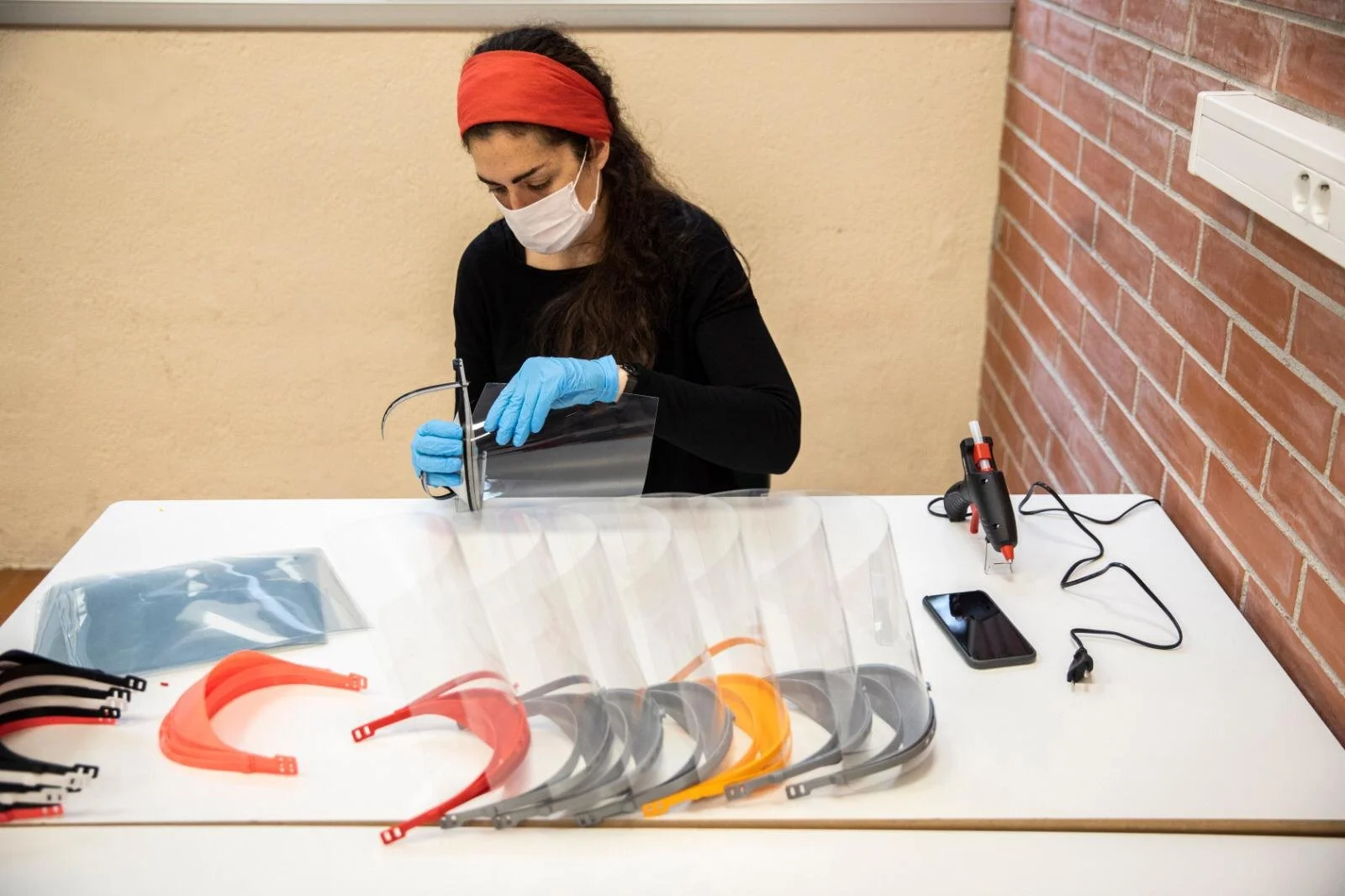  A volunteer assembles face shields produced by the maker community of Barcelona. (Photo by Santi Palacios) 
