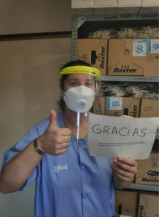  A doctor holds a sign thanking the volunteers that made the face shield he’s wearing. (Photo by Coronavirus Makers) 