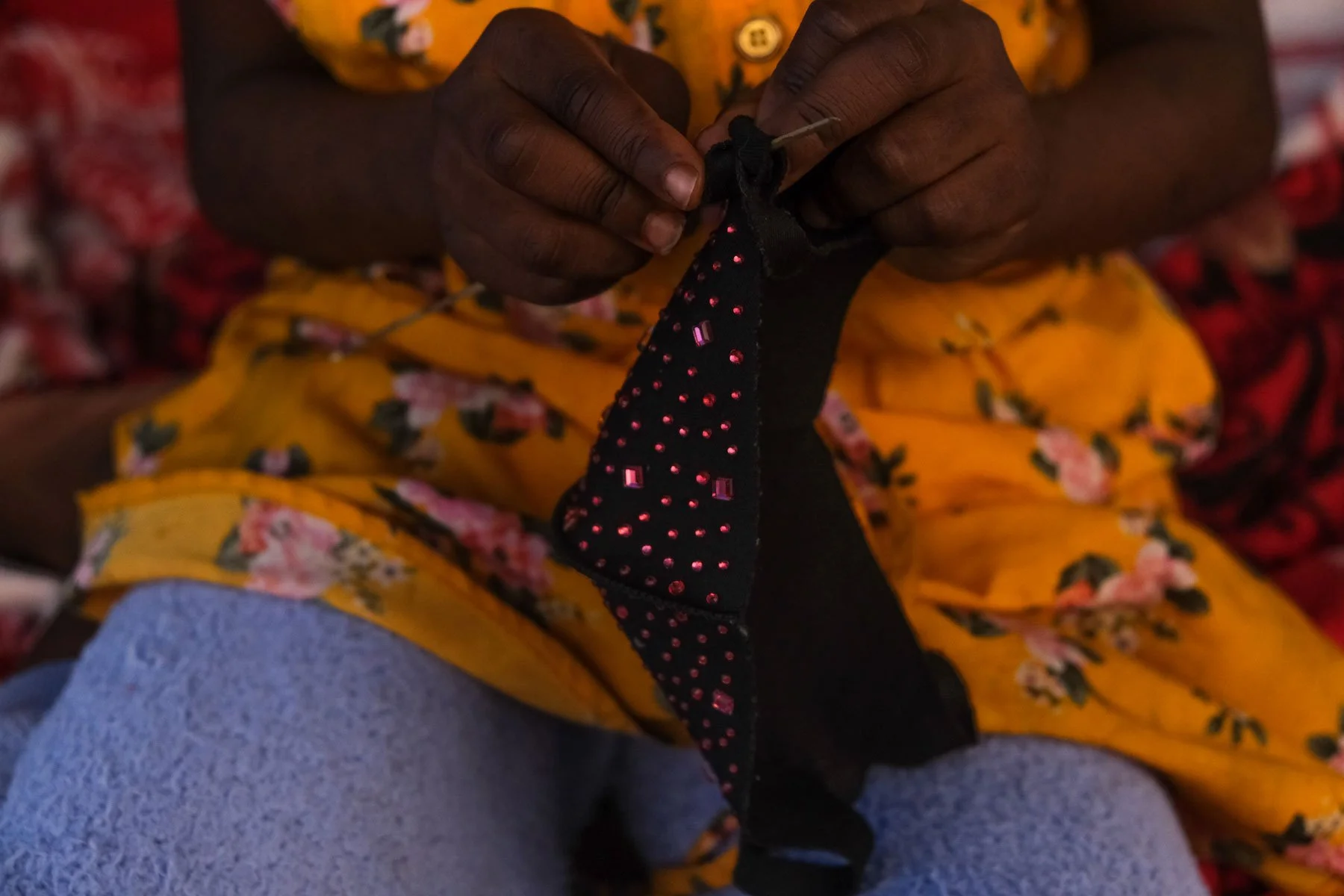  Sadiya Musa plays with a mask, pretending to sew it on her porch. (Photo by Aryana Noroozi/GroundTruth) 