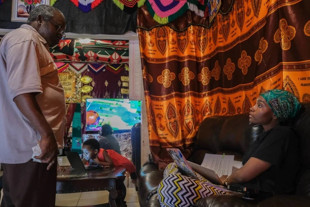  Musa talks to her father Osman Muganga, 71, before her classes. In 2004 when all of the family, but two sisters, immigrated to the U.S., her father was one of the only members of the family to speak English. (Photo by Aryana Noroozi/GroundTruth) 