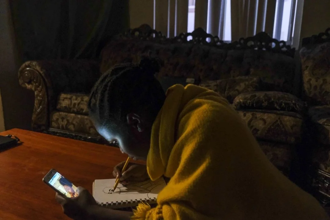  Mwanini Shabani, 15, draws a model from her Instagram feed. Shabani says art is her escape but doesn’t show many people. After finishing homework, she often draws from 7 to 11 p.m. The International Rescue Committee gave Shabani a sketchbook when a 