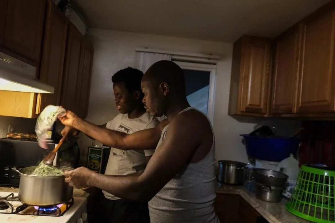  Evode Sindayigaya, 18, prepares dinner with his father Desire Ndayisenga. Ndayisenga recently returned home from work where he is a chef at BJ’s Brewhouse, a restaurant in an upscale neighborhood of San Diego. (Photo by Aryana Noroozi/GroundTruth) 