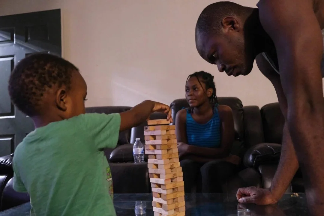  Desire Ndayisenga, 40, plays Jenga with his son Denise, 3. (Photo by Aryana Noroozi/GroundTruth) 