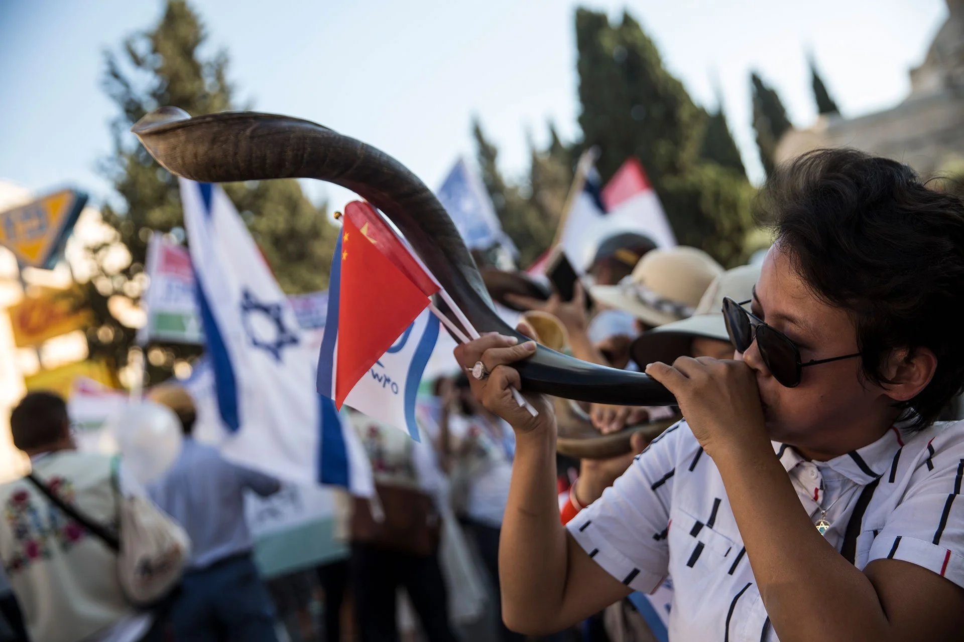 A Christian pilgrim from China blows a Shofar during a parade in Jerusalem on September 27,2018. Thousands of Christians from around the world participated in the march which was one of the major events of the week long Feast of Tabernacles festival 