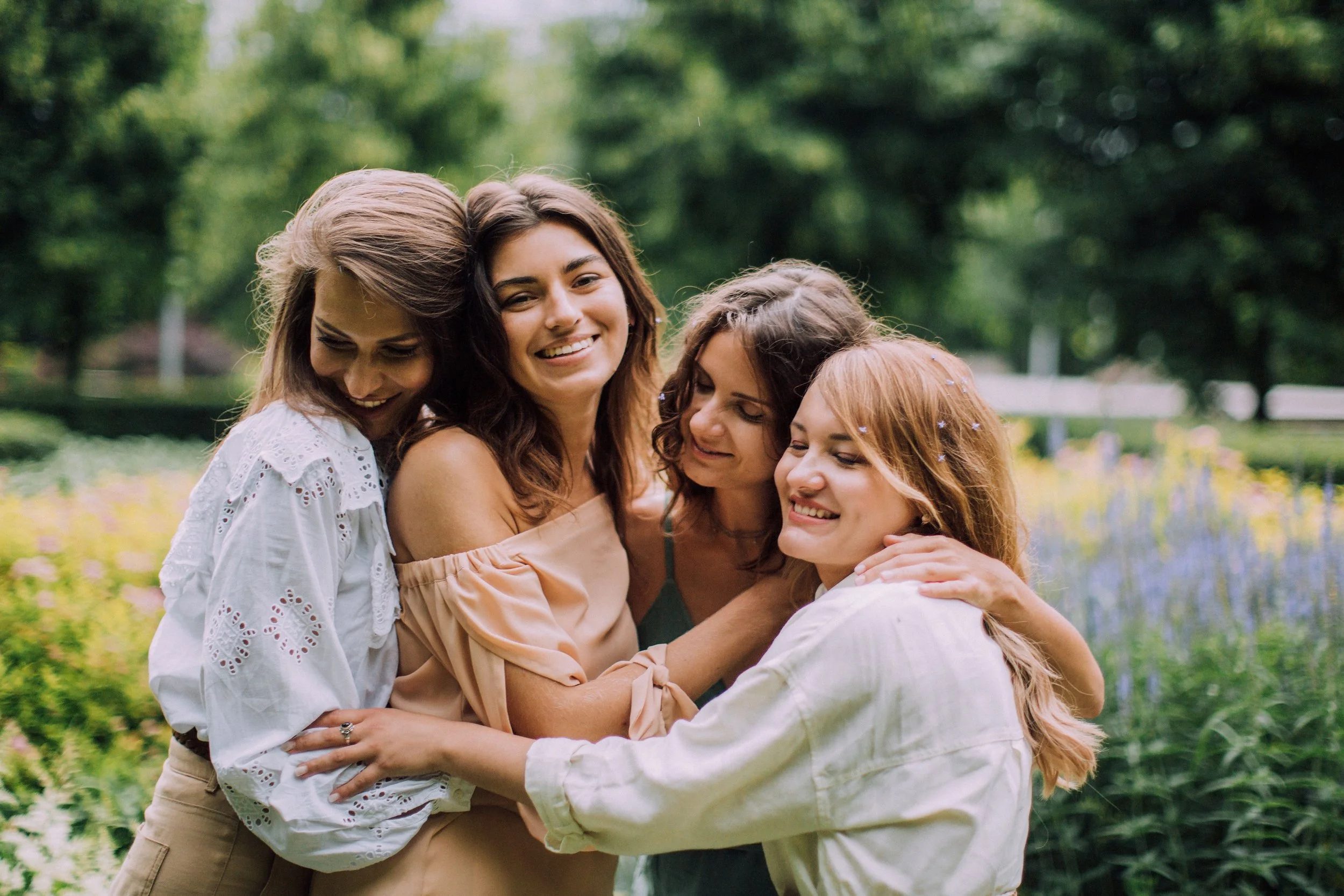 A photo of 4 women embracing each other in a group hug as imagery to represent cancer group therapy