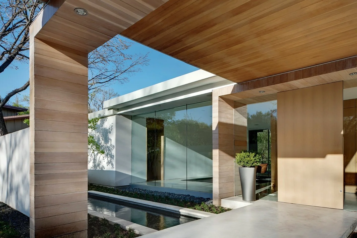 Arrival is part of the architecture.

A layered entry of warm wood, soft light, and water creates a quiet transition from outside to in, where rift-cut white oak begins to define movement and frame the spaces beyond. The water, the overhang, the fram