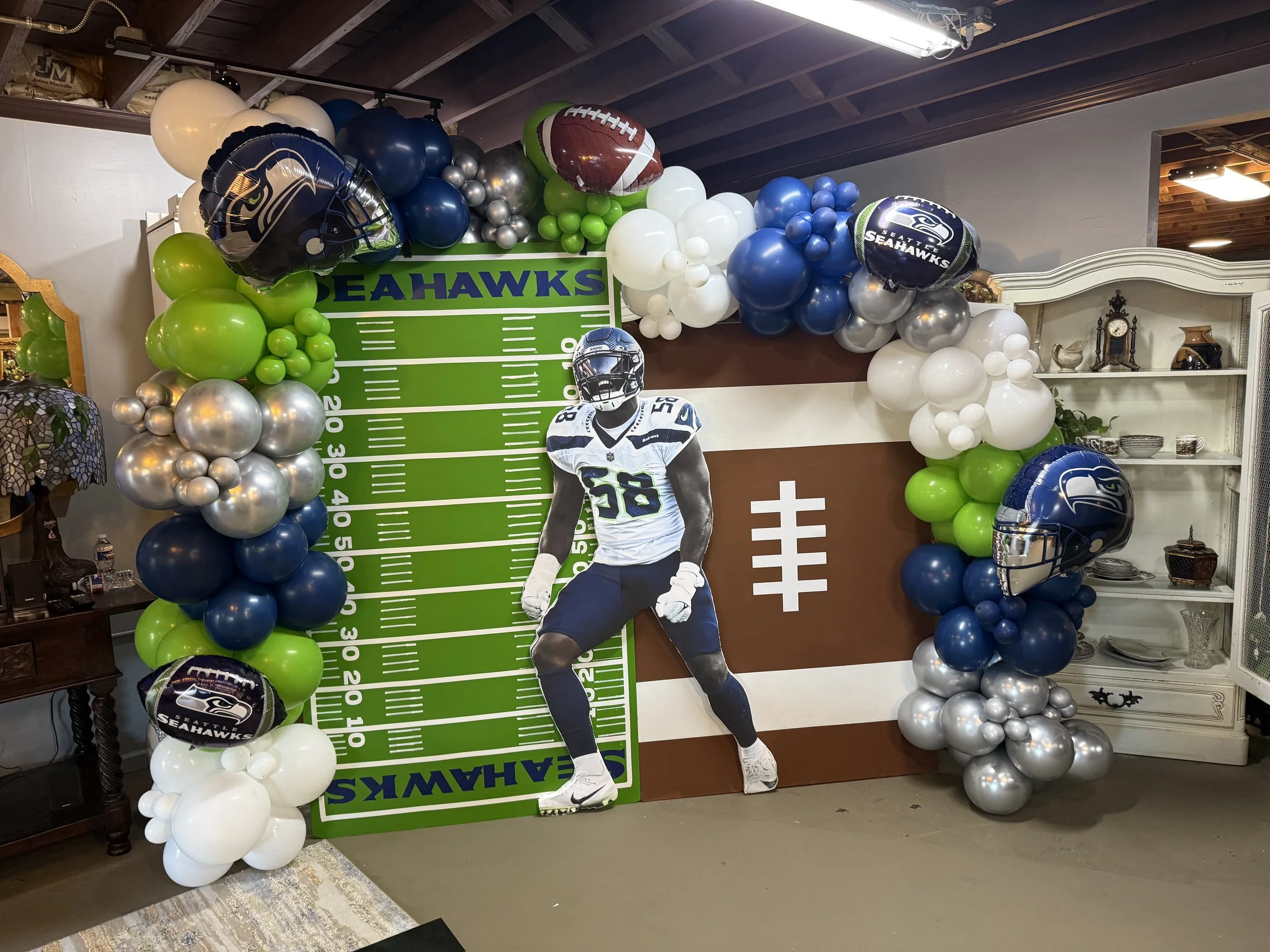 Decorative display with balloons and football-themed cutouts celebrating the Seattle Seahawks football team.