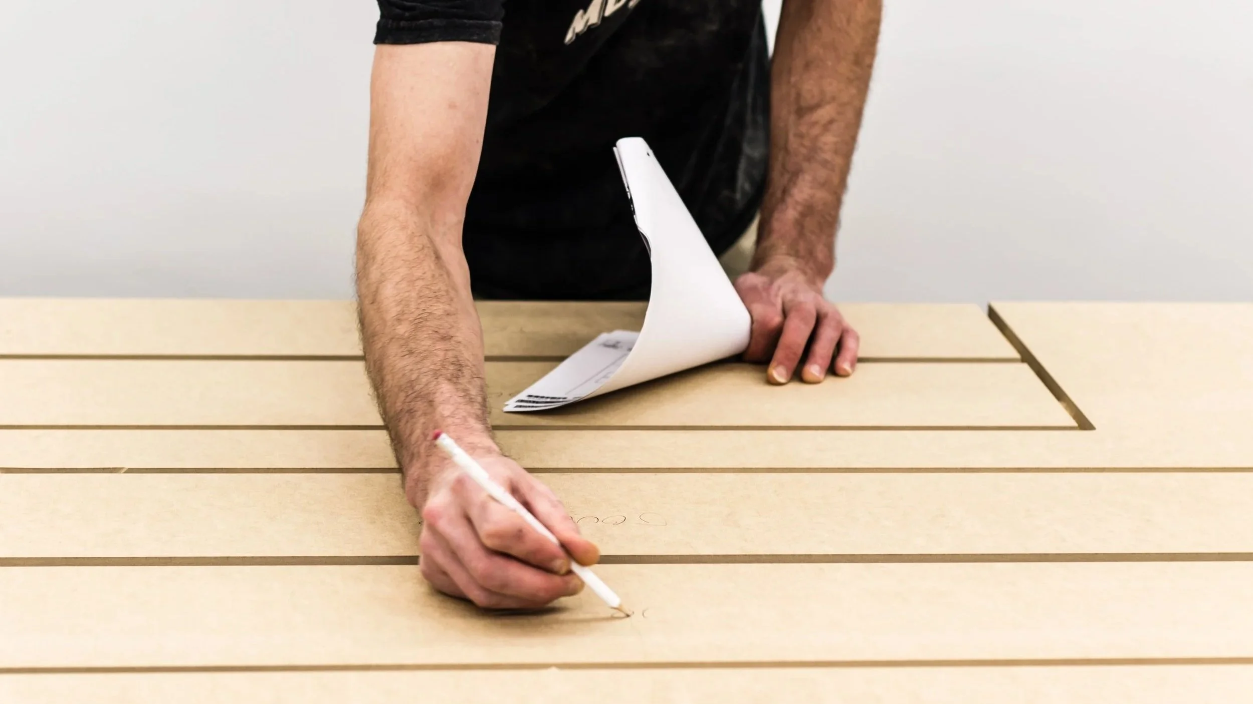 Traçage d’un panneau avant sa fabrication dans l’atelier Cuisines Steam