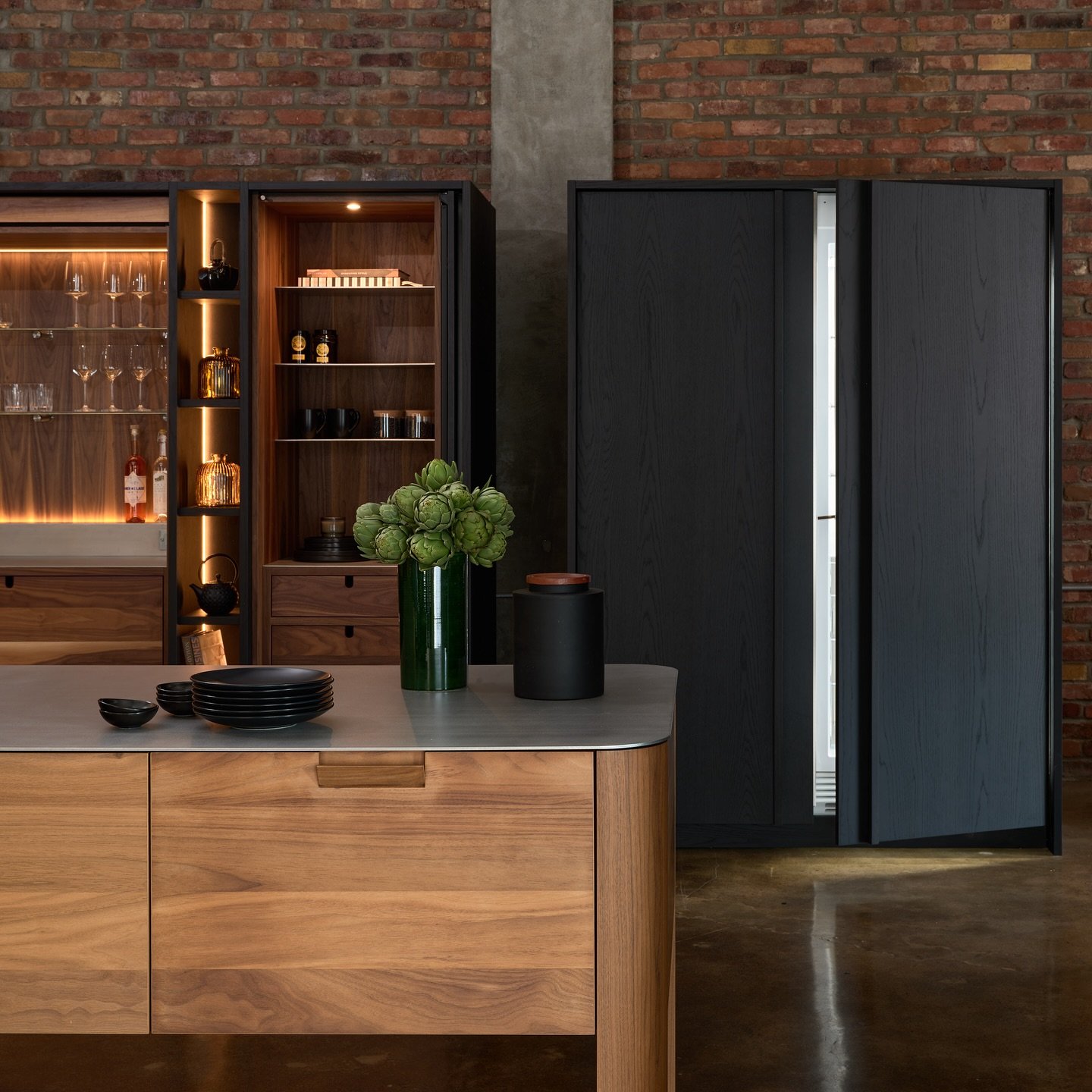 🌿 Une cuisine qui allie &eacute;l&eacute;gance et modernit&eacute; ! Le mariage entre le bois de noyer et le ch&ecirc;ne teint&eacute; noir apporte une chaleur naturelle, tandis que les touches de marbre noir et d&rsquo;acier inoxydable ajoutent une