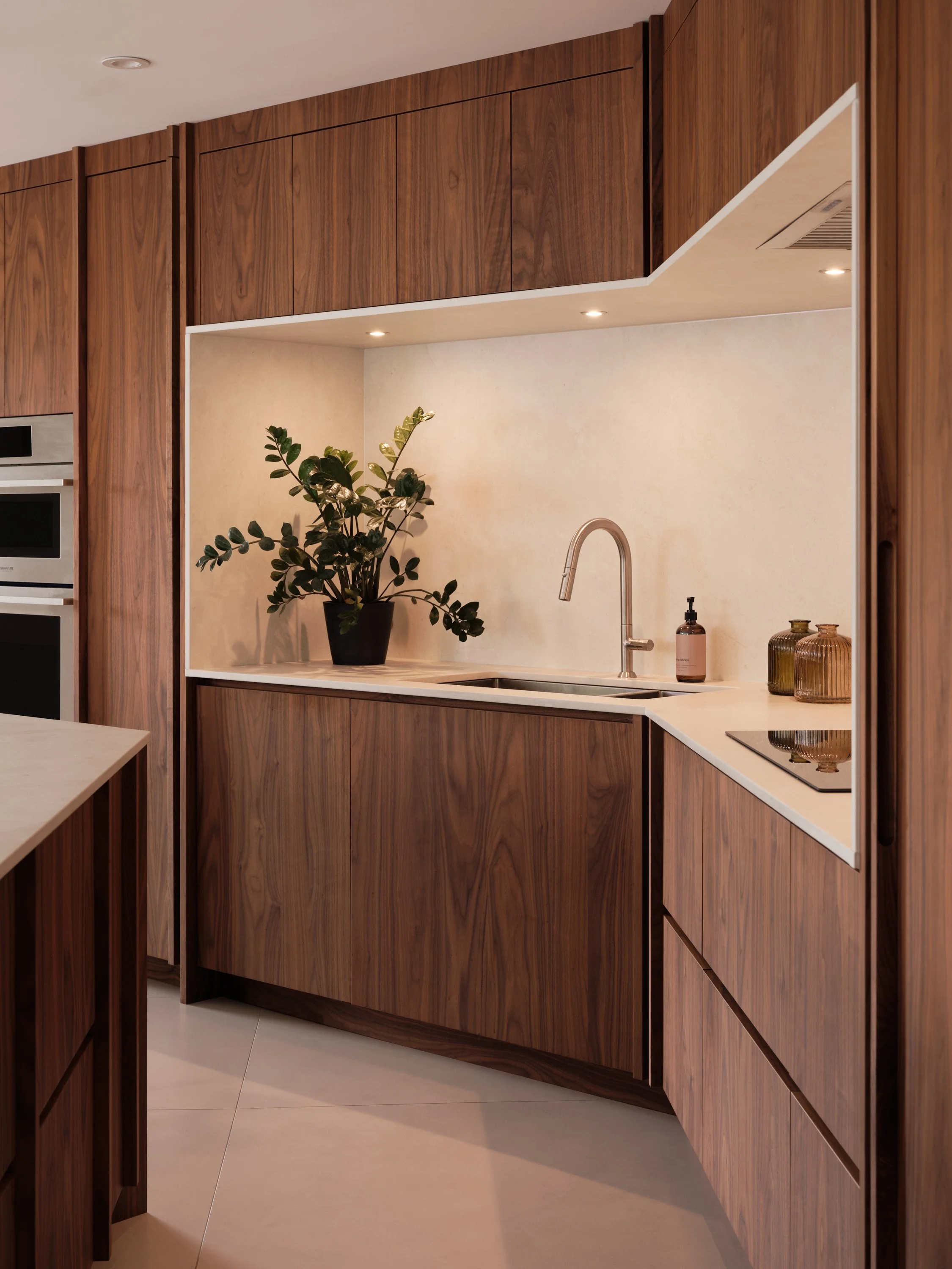 Aménagement de cuisine sur mesure en noyer avec îlot et rangements intégrés