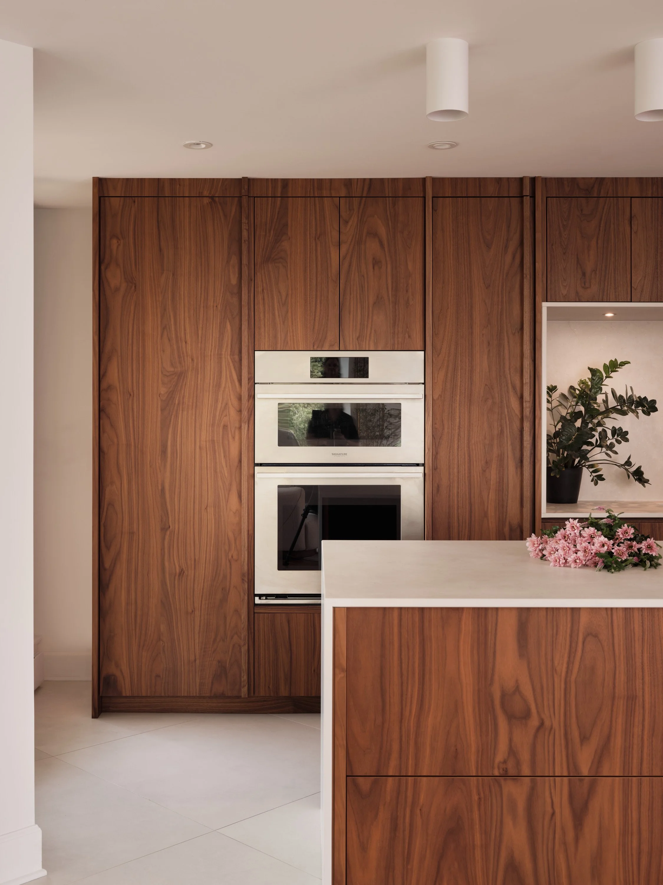 Cuisine en noyer sur mesure avec électroménagers intégrés et îlot central